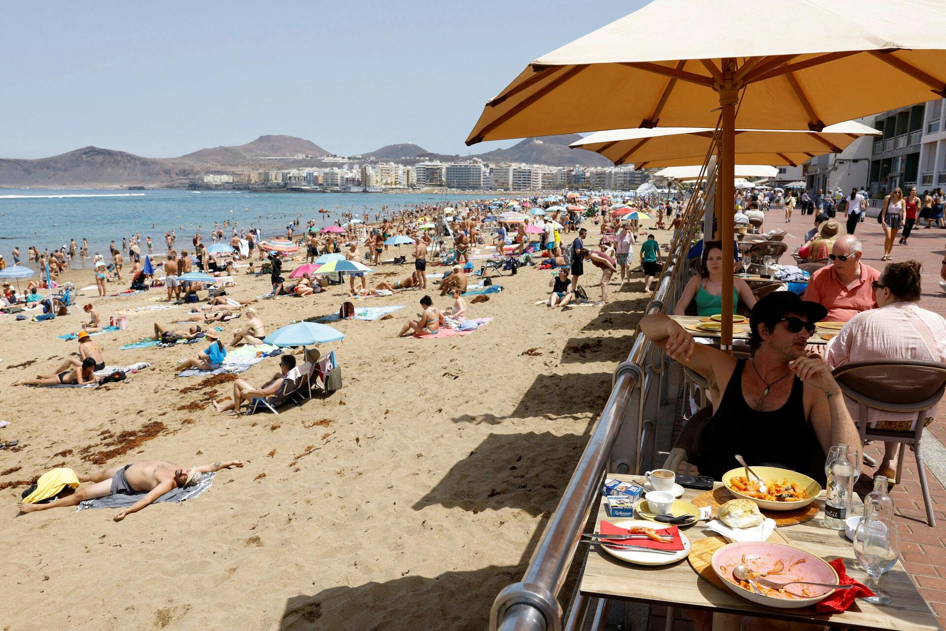 FILE PHOTO: Tourists eat on a terrace next to Las Canteras Beach in Las Palmas de Gran Canaria. Spain, April 13, 2024. REUTERS/Borja Suarez/File Photo