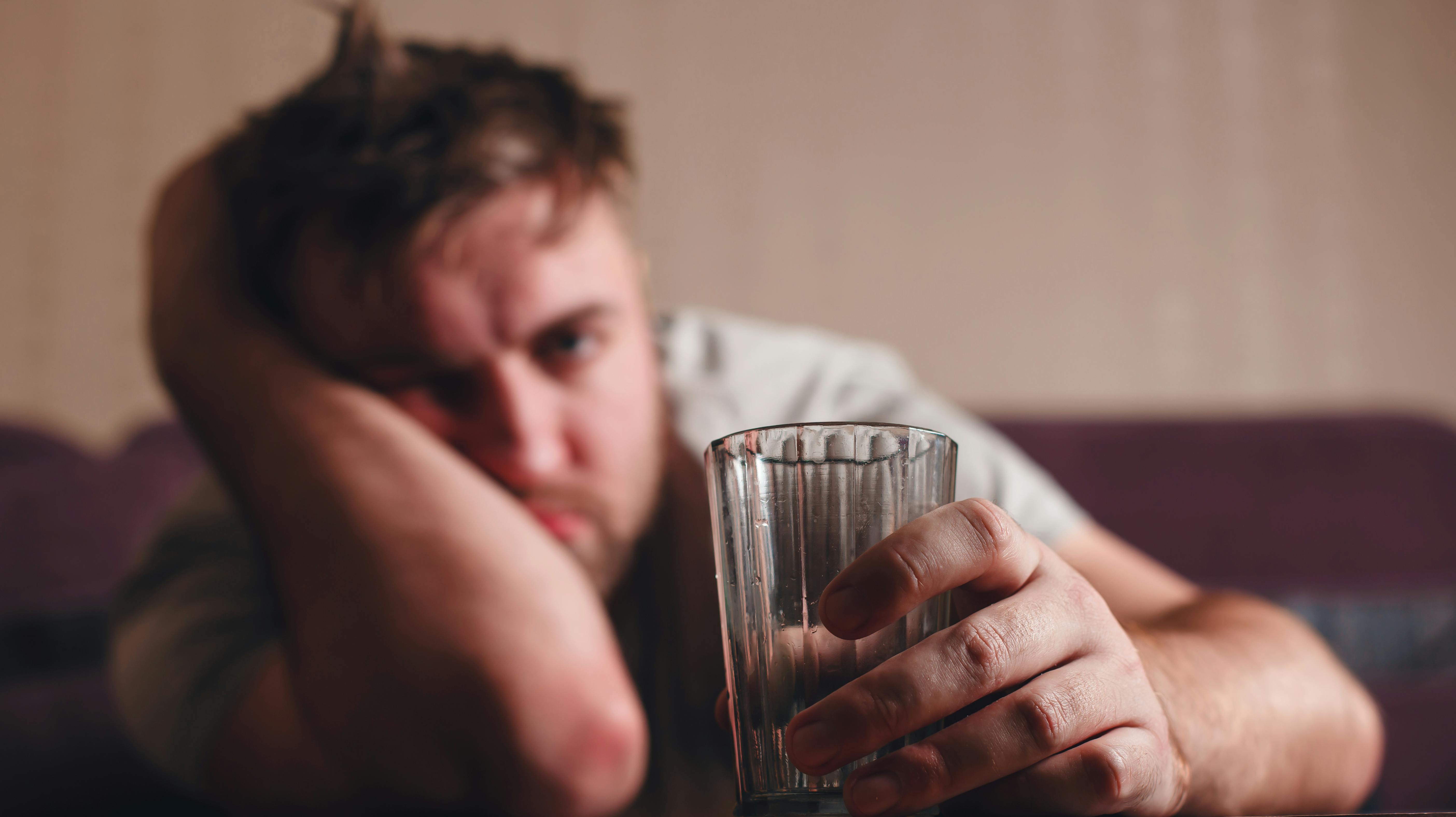 Hangover depressed man after hard drinking. Alcohol abuse problem concept.