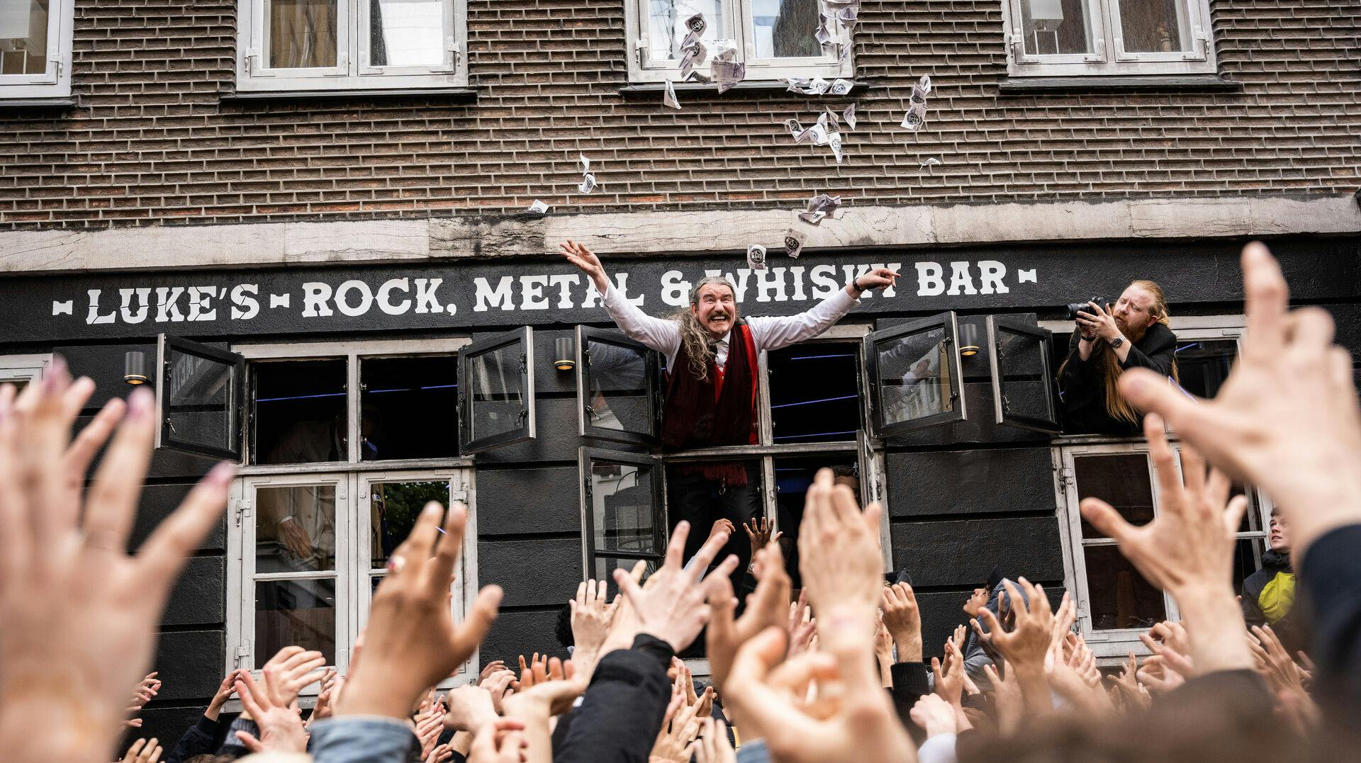 Bitcoin-piraten Niklas Nikolajsen har tjent så meget på de elektroniske penge, at han under en happening i København kan kaste rundt med en lille del af sin enorme fysiske gevinst .