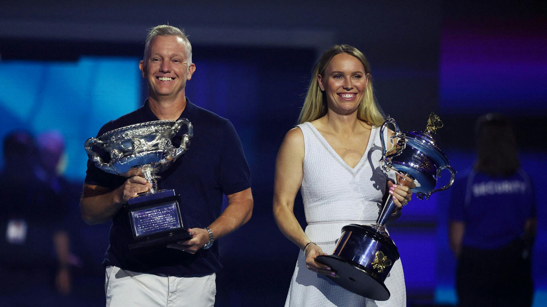 Caroline Wozniacki bar sammen med svenske Thomas Johansson trofæerne for Grand Slam-turneringen Australian Open ind på første spilledag i Melbourne.