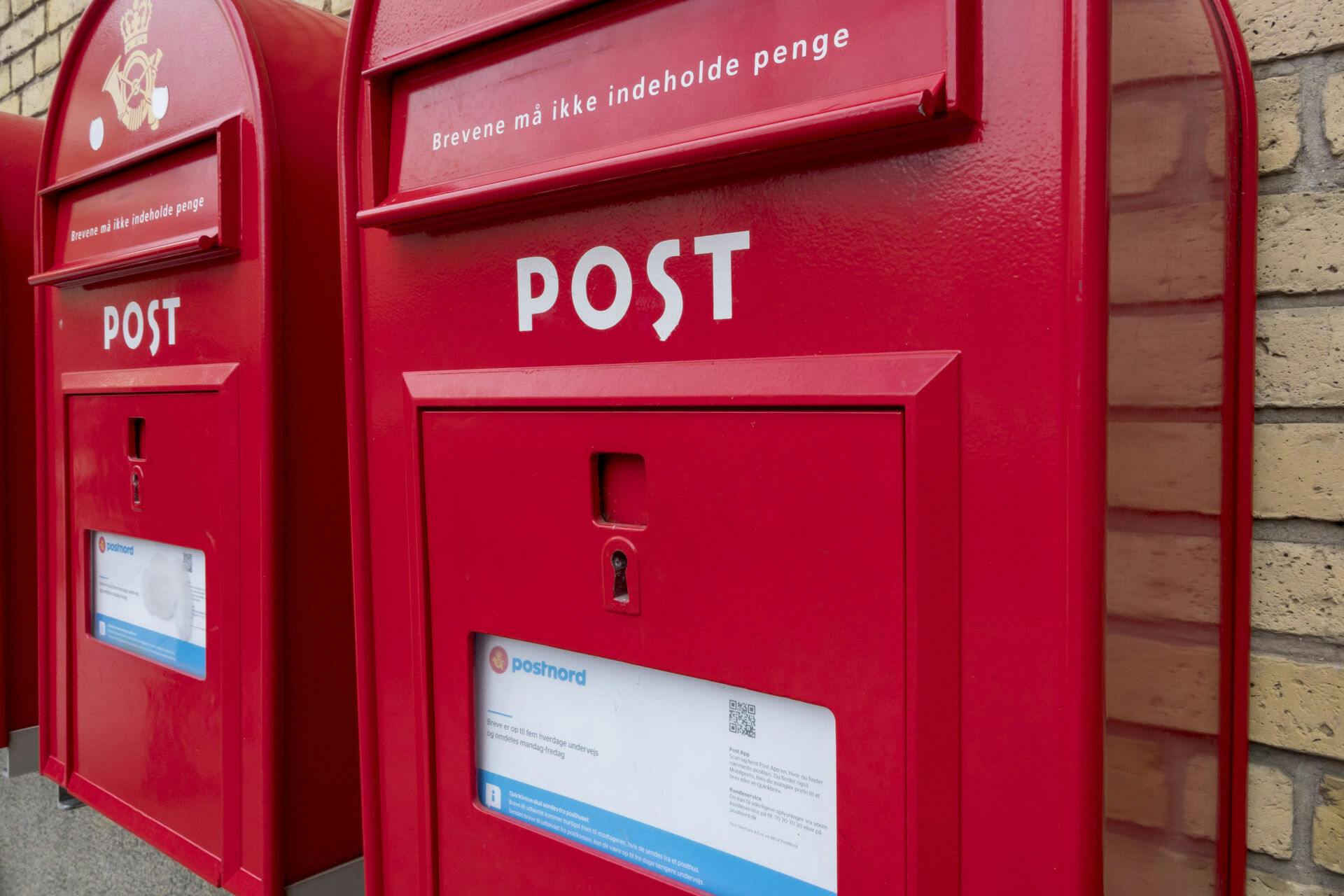 Røde postkasser på murstensvæg ved hovedbanegård i Aarhus. PostDanmark, PostNord postekspedition, brevforsendelser, breve, postvæsen, offentlig service, outsourcing, dårlig service, postbesørgelse, PostDanmarks nedlæggelse, postomdeling, posten. Firmalogo, virksomhedslogo, posttegn, postlogo, post-logo. Danish mail, letterbox, mailbox, 