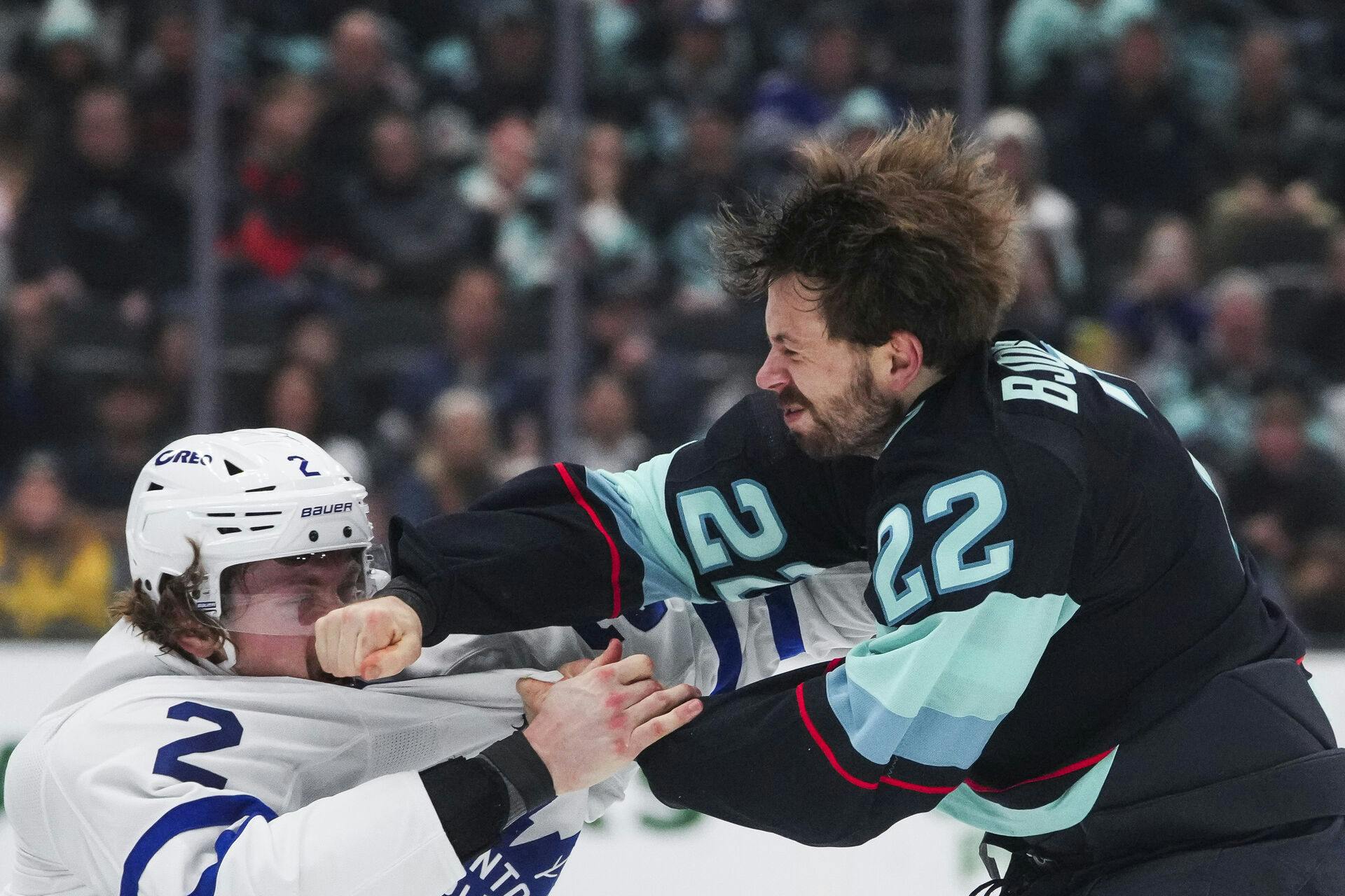 Toronto Maple Leafs defenseman Simon Benoit, left, gets punched by Seattle Kraken right wing Oliver Bjorkstrand, right, as they fight during the second period of an NHL hockey game Thursday, Feb. 6, 2025, in Seattle. (AP Photo/Lindsey Wasson)