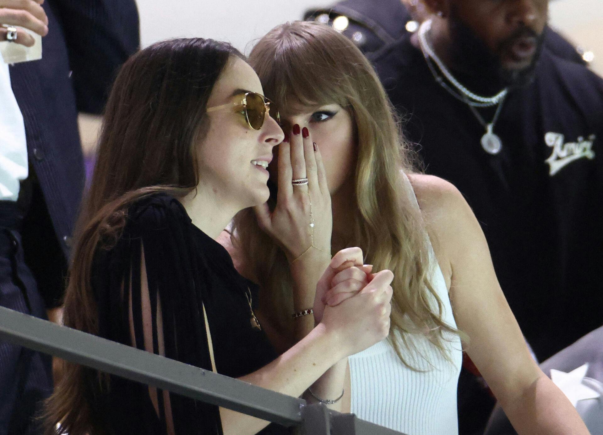 Taylor Swift (th.) hvisker hemmelige ting til HAIM-sangerinden Alana Haim.