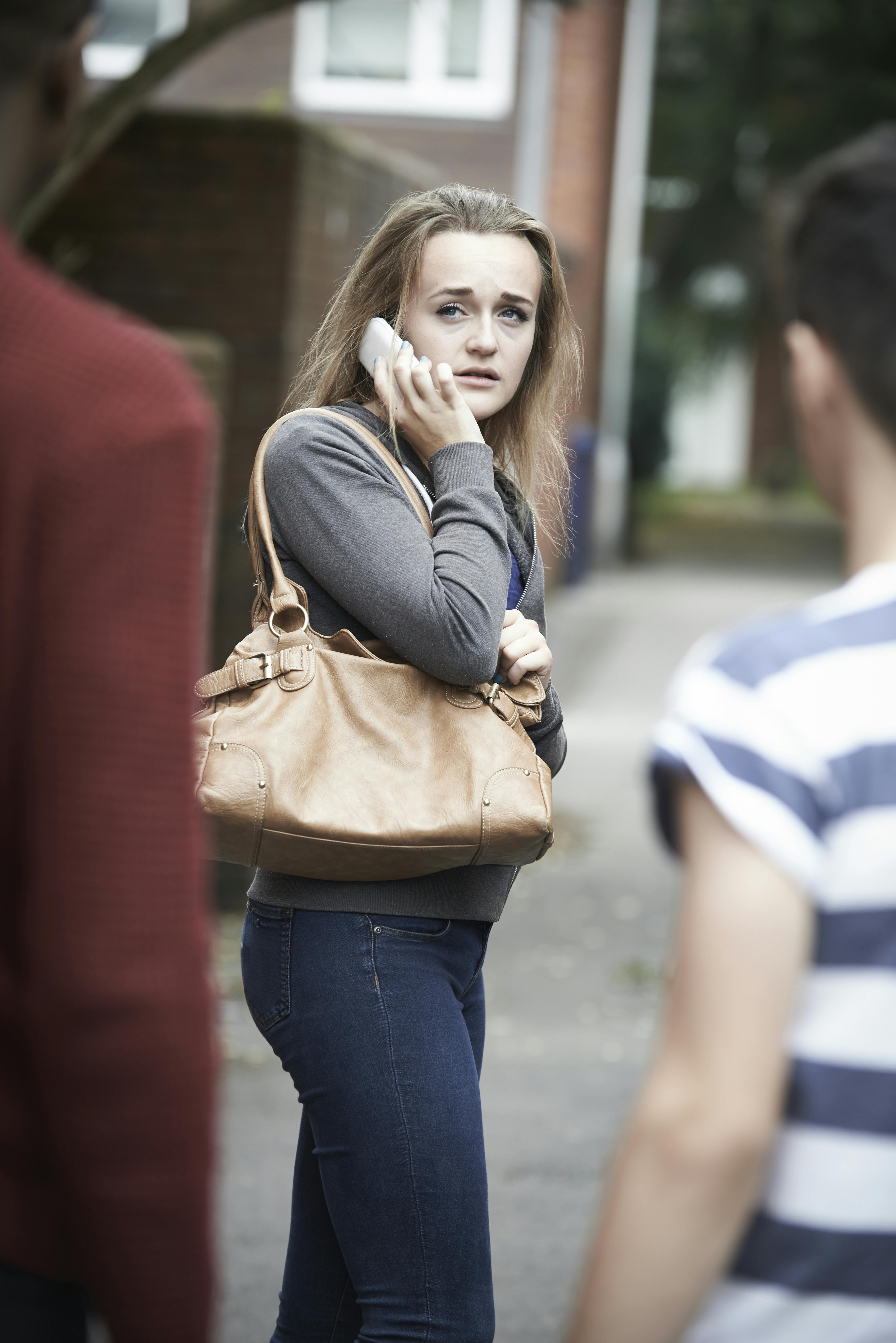 Teenage Girl On Mobile Phone Feeling Intimidated As She Walks Home