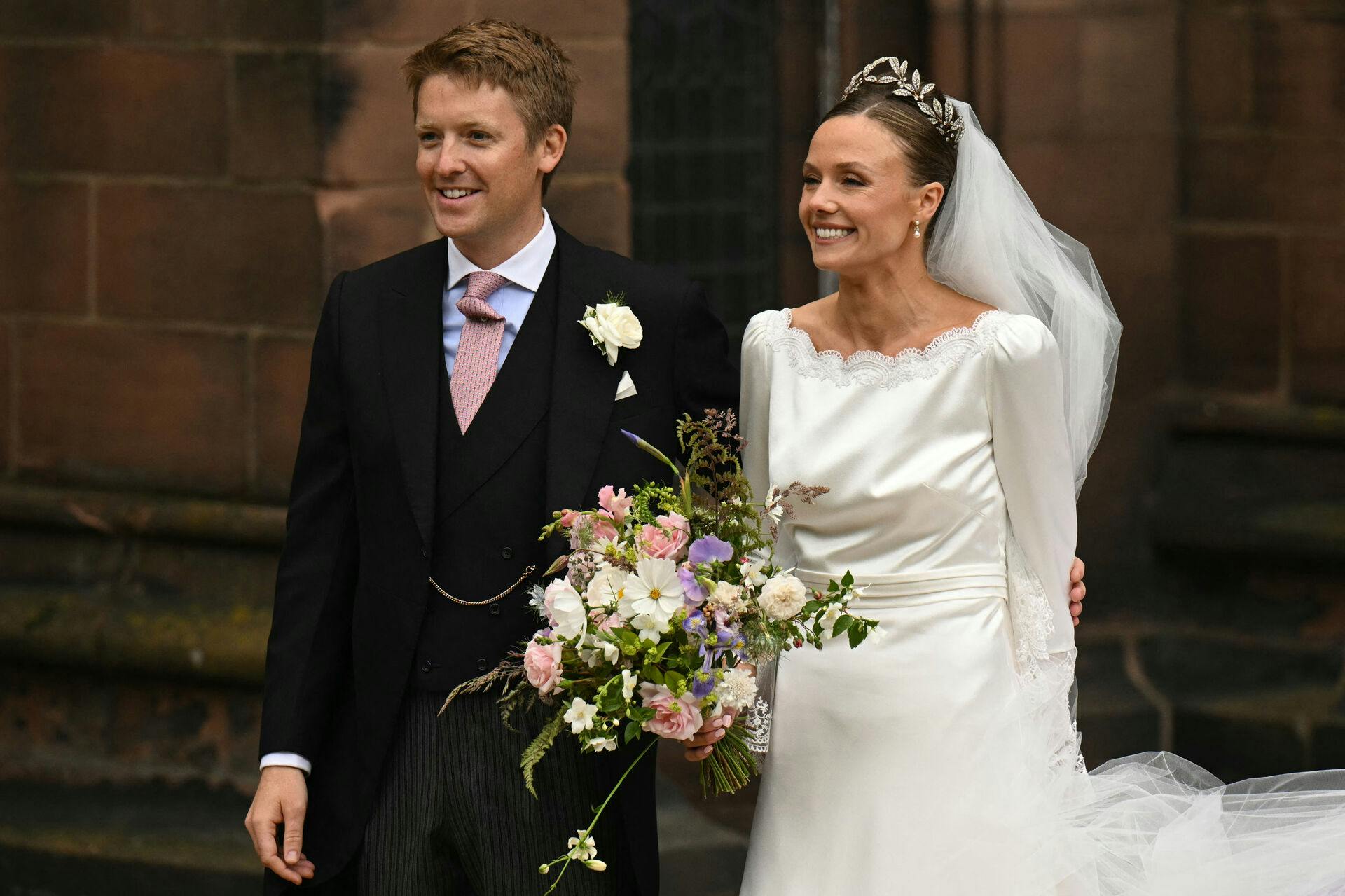 Groom Hugh Grosvenor, Duke of Westminster, and bride Olivia Henson pose for a photograph as they leave after their wedding service at Chester Cathedral in Chester, northern England, on June 7, 2024. Oli SCARFF / AFP