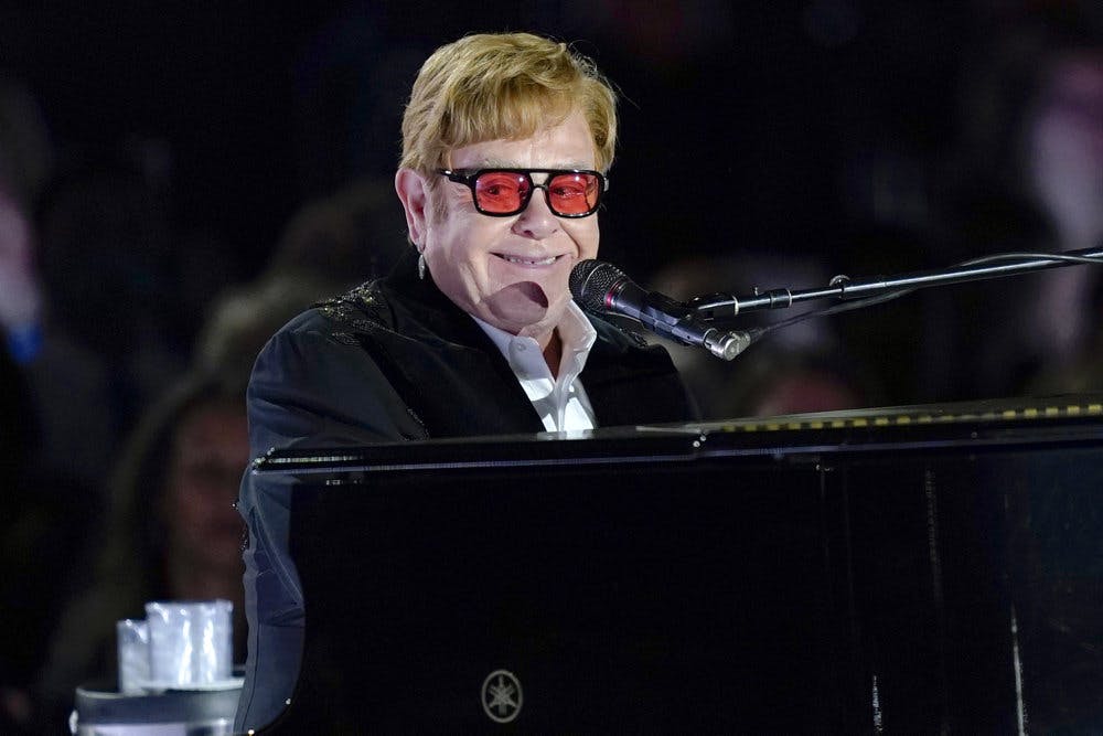 Briten sir Elton John har optrådt med sine mange hits verden over. I 1970 fik han sit første hit på den britiske top-10. Det var "Your Song". Han er nu 77 år. Billedet er fra 2022, da han spillede på plænen ved Det Hvide Hus i Washington D.C. - Foto