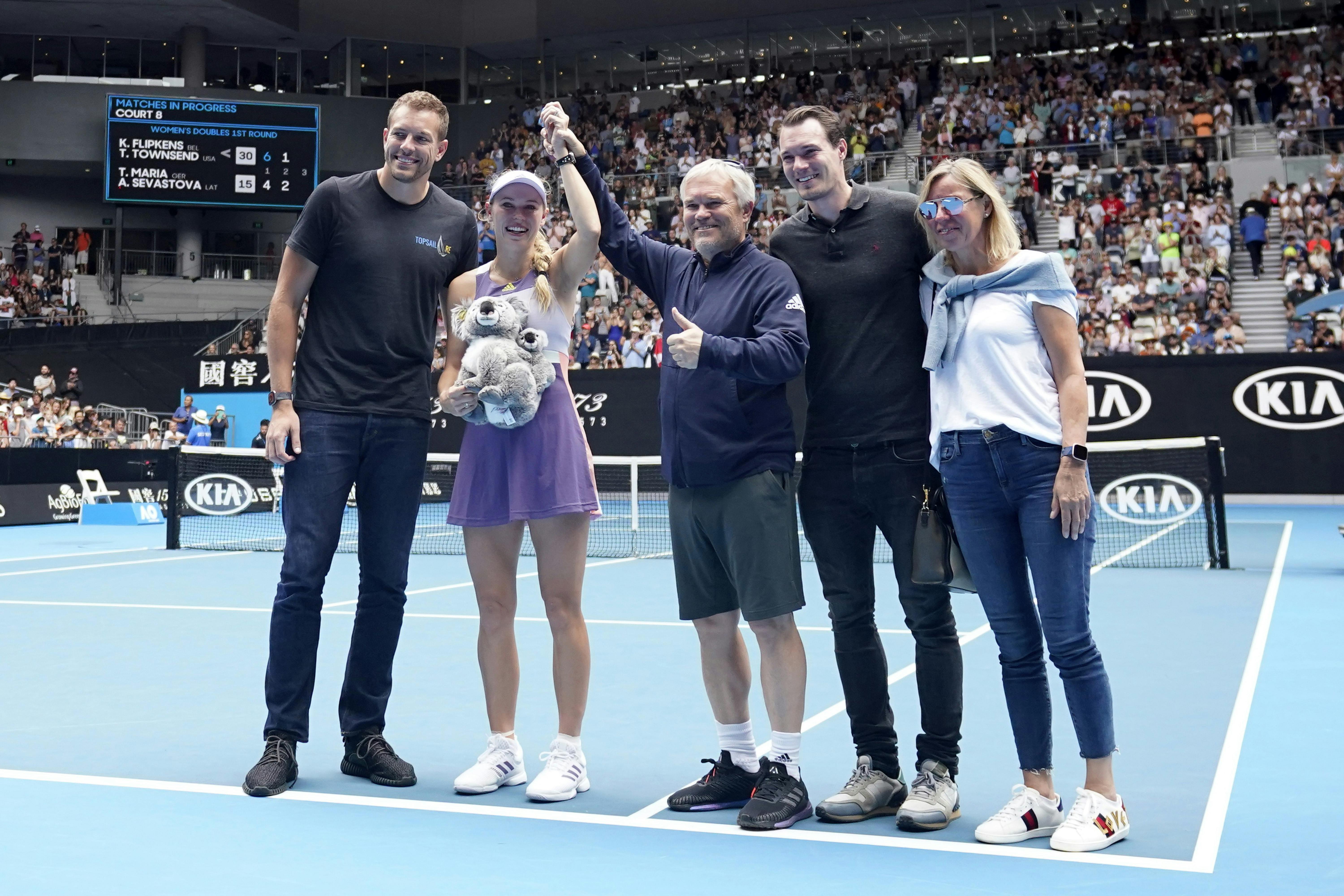 Tennis - Australian Open - Third Round - Melbourne Park, Melbourne, Australia - January 24, 2020 - Denmark's Caroline Wozniacki poses for pictures with her husband David Lee, coach and father Piotr Wozniacki, mother Anna Wozniacki and brother Patrik Wozniacki, as she heads into retirement after losing the match against Tunisia's Ons Jabeur. REUTERS/Kim Hong-Ji