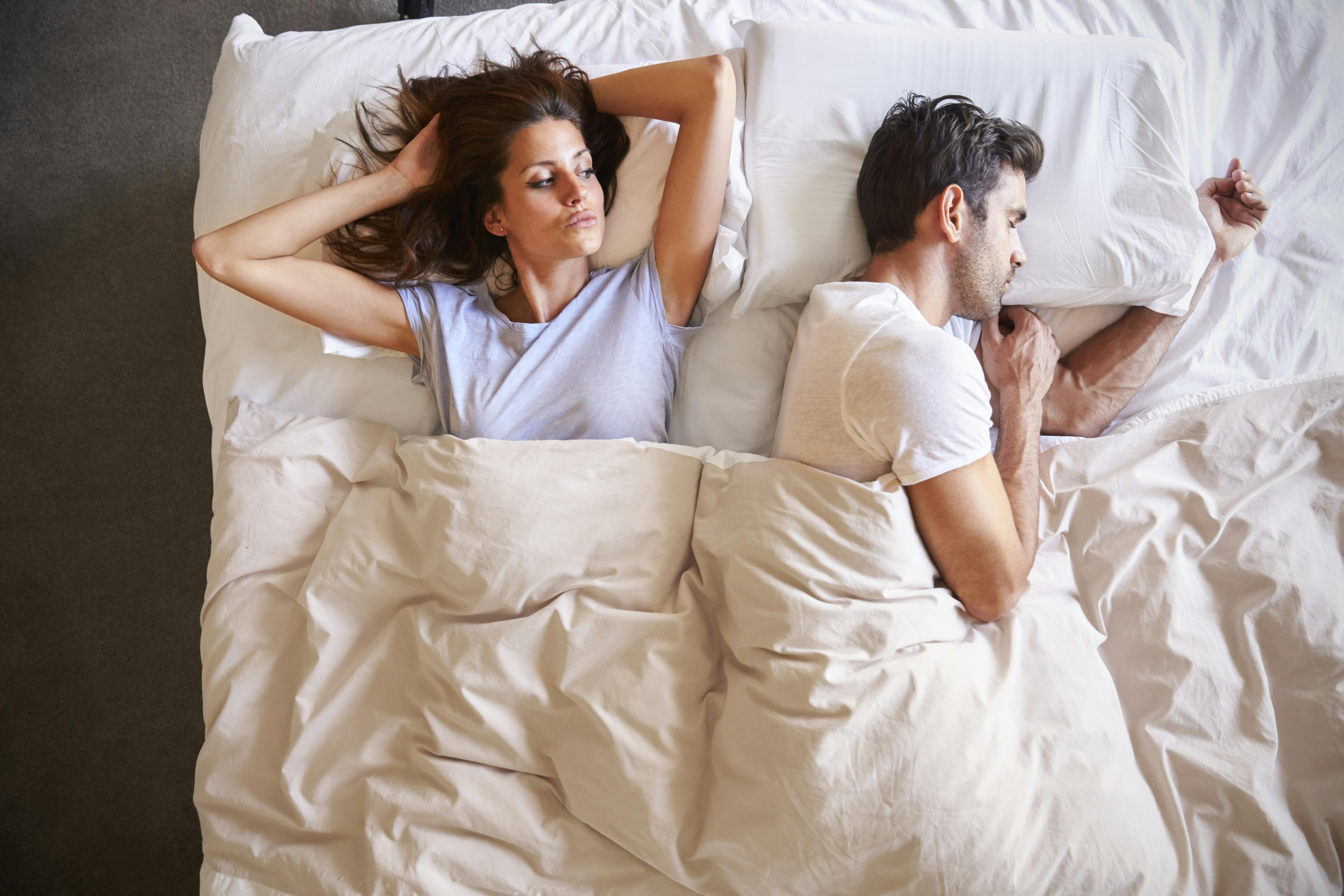 Overhead View Of Couple With Relationship Problems Lying In Bed