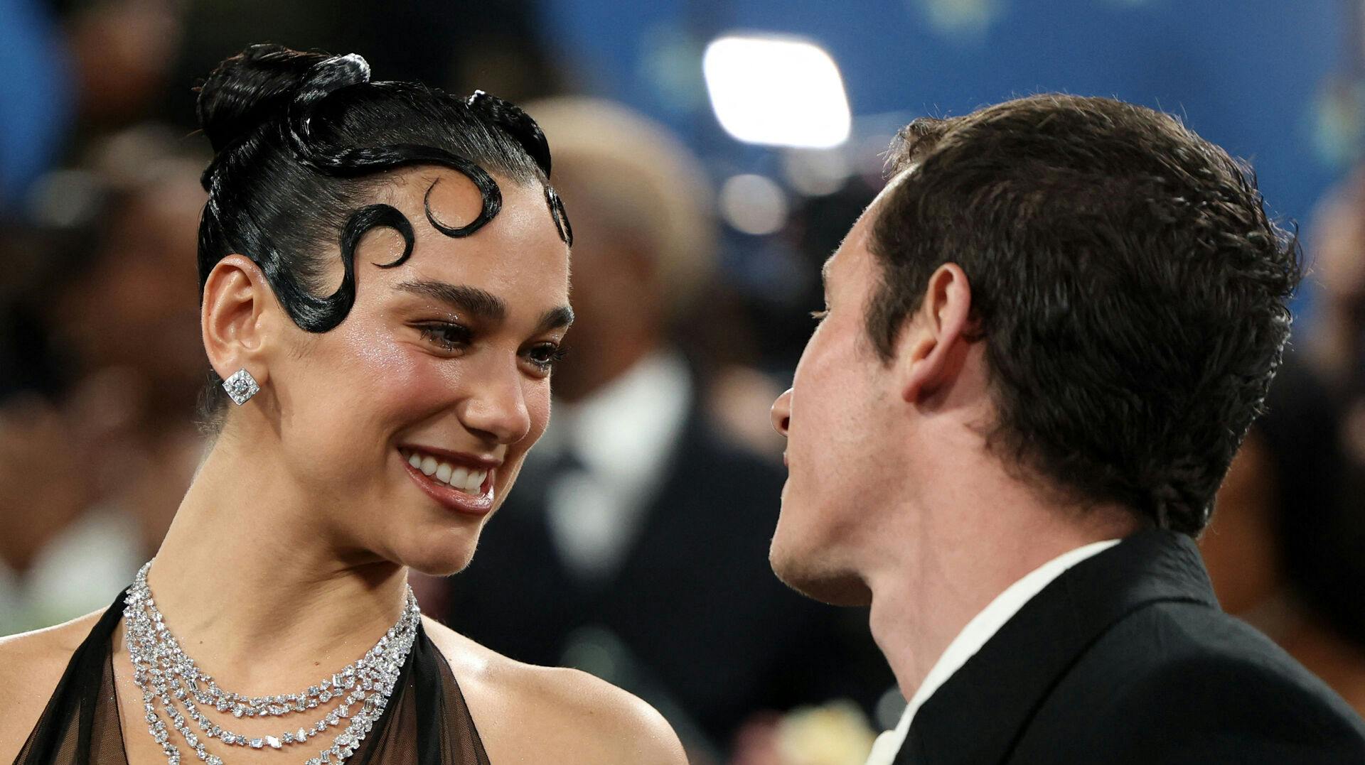 Dua Lipa and Callum Turner interact during the Met Gala,
