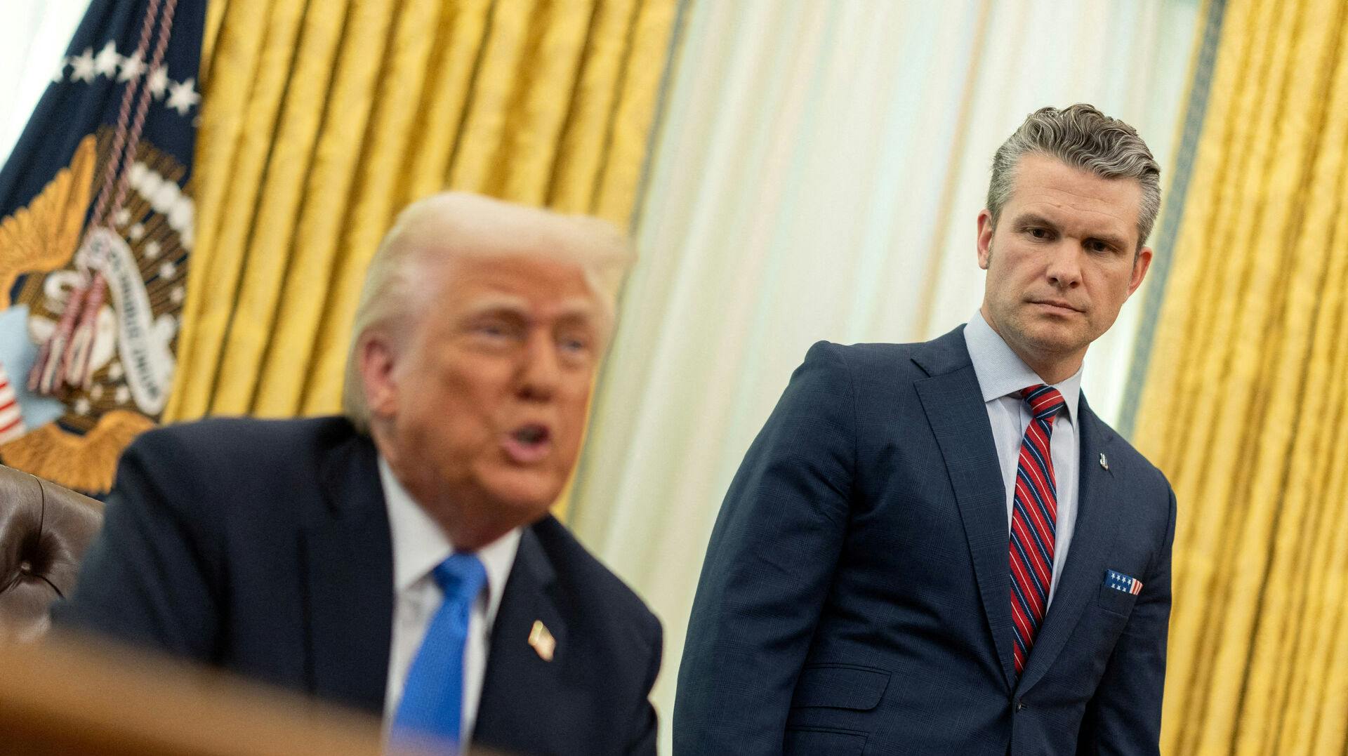 FILE PHOTO: U.S. Defense Secretary Pete Hegseth looks on, as President Donald Trump delivers remarks, in the Oval Office at the White House, in Washington, D.C., U.S., March 21, 2025. REUTERS/Carlos Barria/File Photo