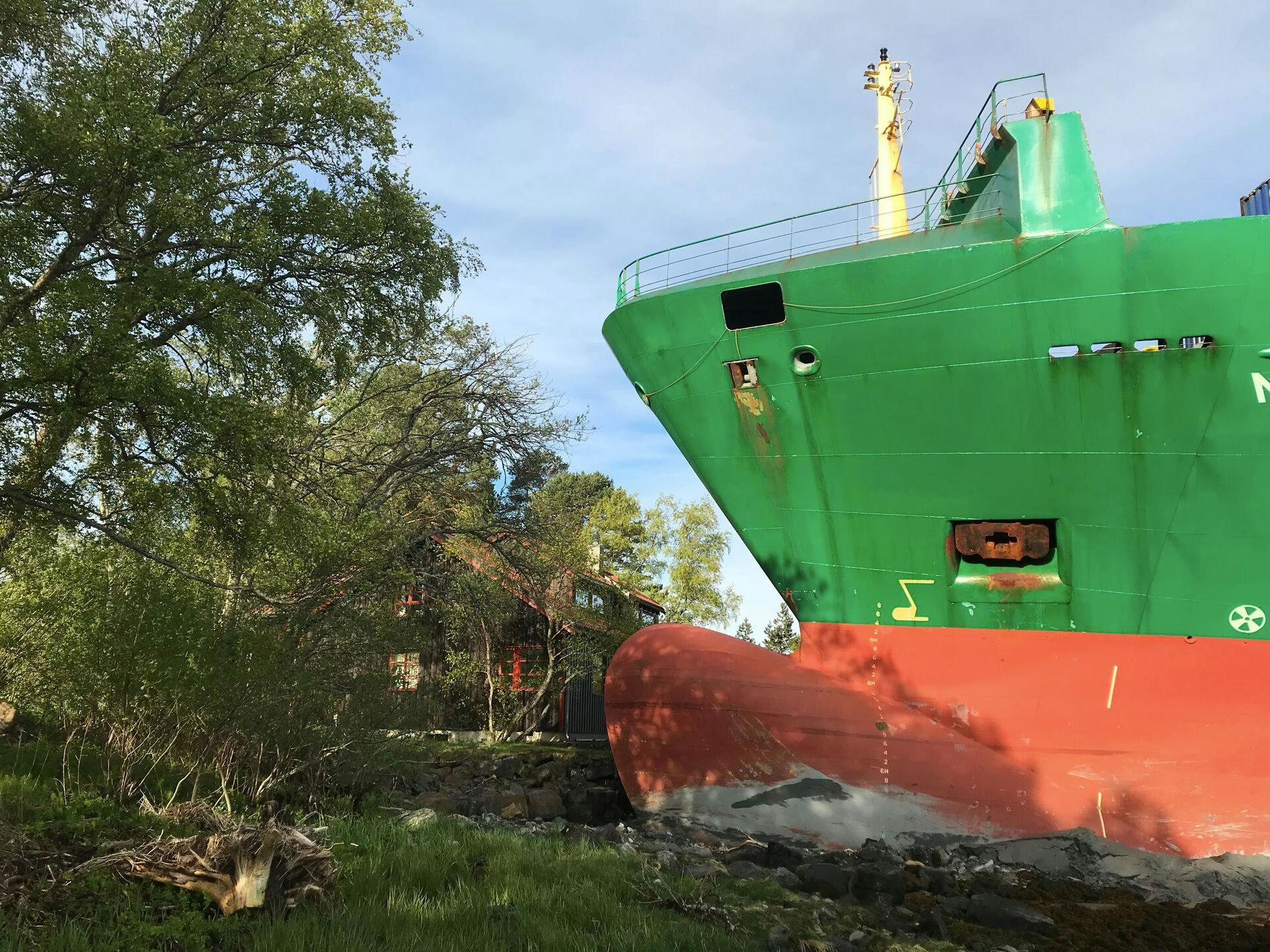 Det grønne containerskib NCL "Salten" står solidt plantet på kysten ved Trondheimsfjorden – kun få meter fra nærmeste bolig i Byneset. Ingen kom til skade, men morgenstunden blev alt andet end almindelig.