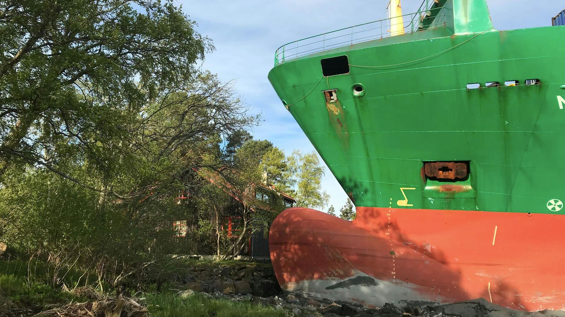 Det grønne containerskib NCL "Salten" står solidt plantet på kysten ved Trondheimsfjorden – kun få meter fra nærmeste bolig i Byneset. Ingen kom til skade, men morgenstunden blev alt andet end almindelig.
