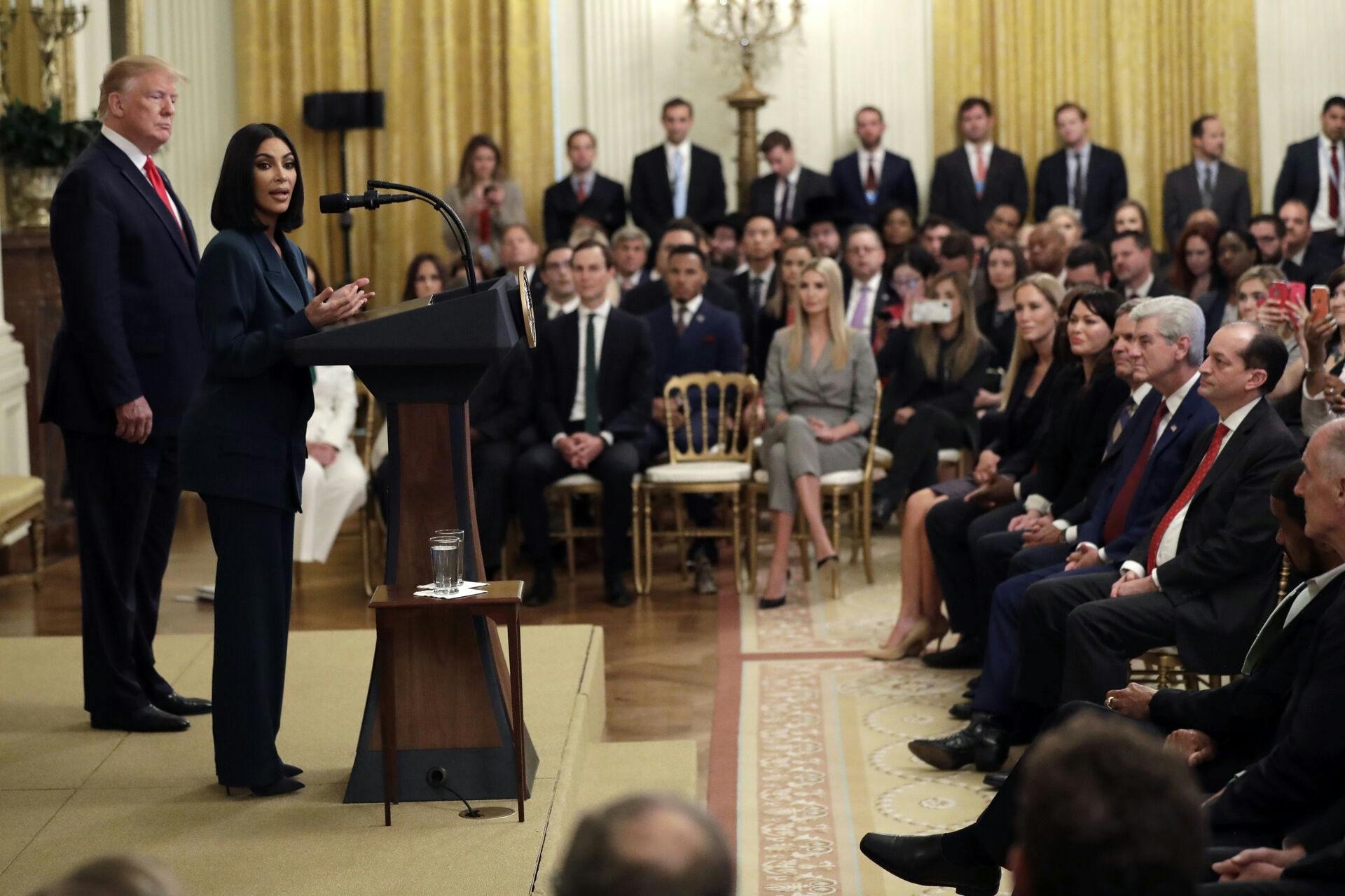 Præsident Donald Trump lytter til Kim Kardashian West, som er blandt de kendisser, der har kæmpet for reformer af straffesystemet, mens hun taler under et arrangement om anden chance-ansættelser i Østfløjen i Det Hvide Hus, torsdag den 13. juni 2019, i Washington. 