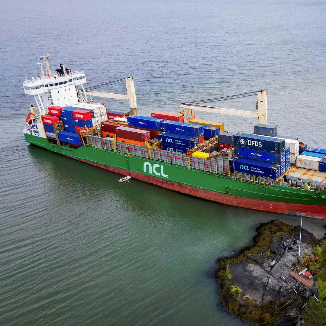 An areal view shows a 135-meter-long container ship by the shore in the Trondheimsfjord outside Byneset by Trondheim, Norway, on May 22, 2025, after it ran aground almost hitting a house. (Photo by Jan Langhaug / NTB / AFP) / Norway OUT