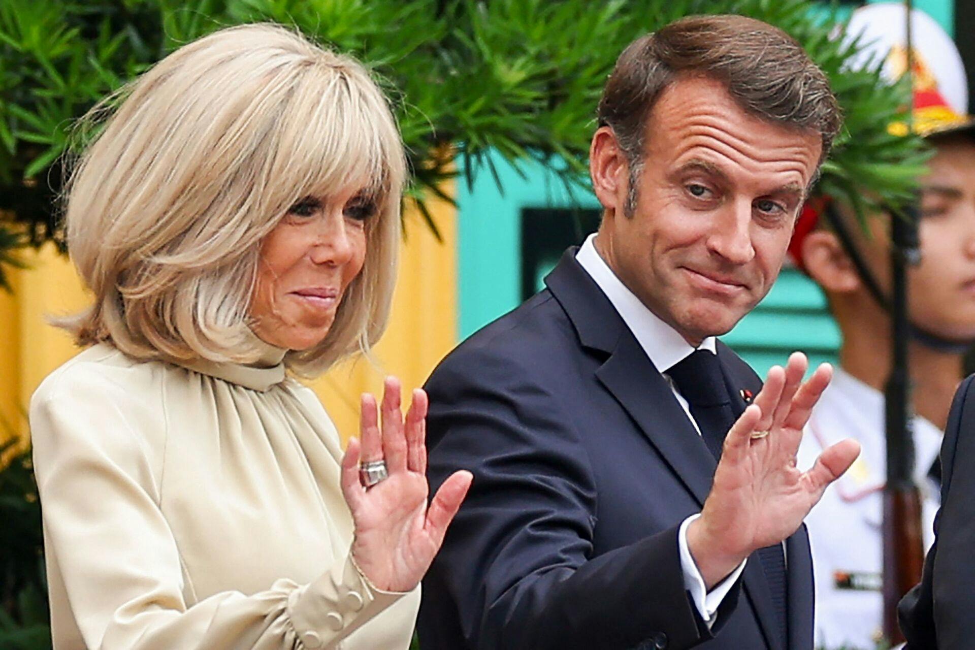 En video viser, hvordan Brigitte Macron planter sine hænder i hovedet på sin mand.
