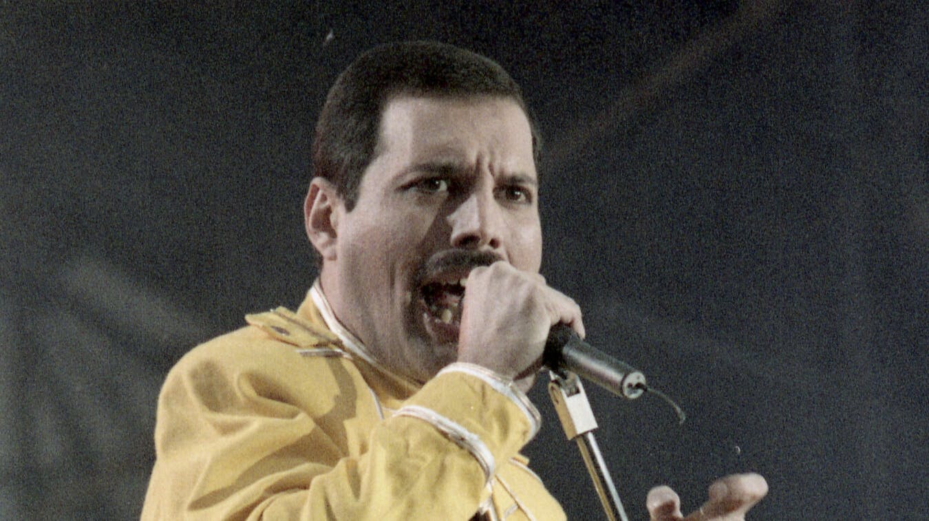 The lead singer of the band Queen, Freddie Mercury, singing during an open air concert in Cologne, Germany on July 20, 1986. (AP Photo/Marco Arndt)