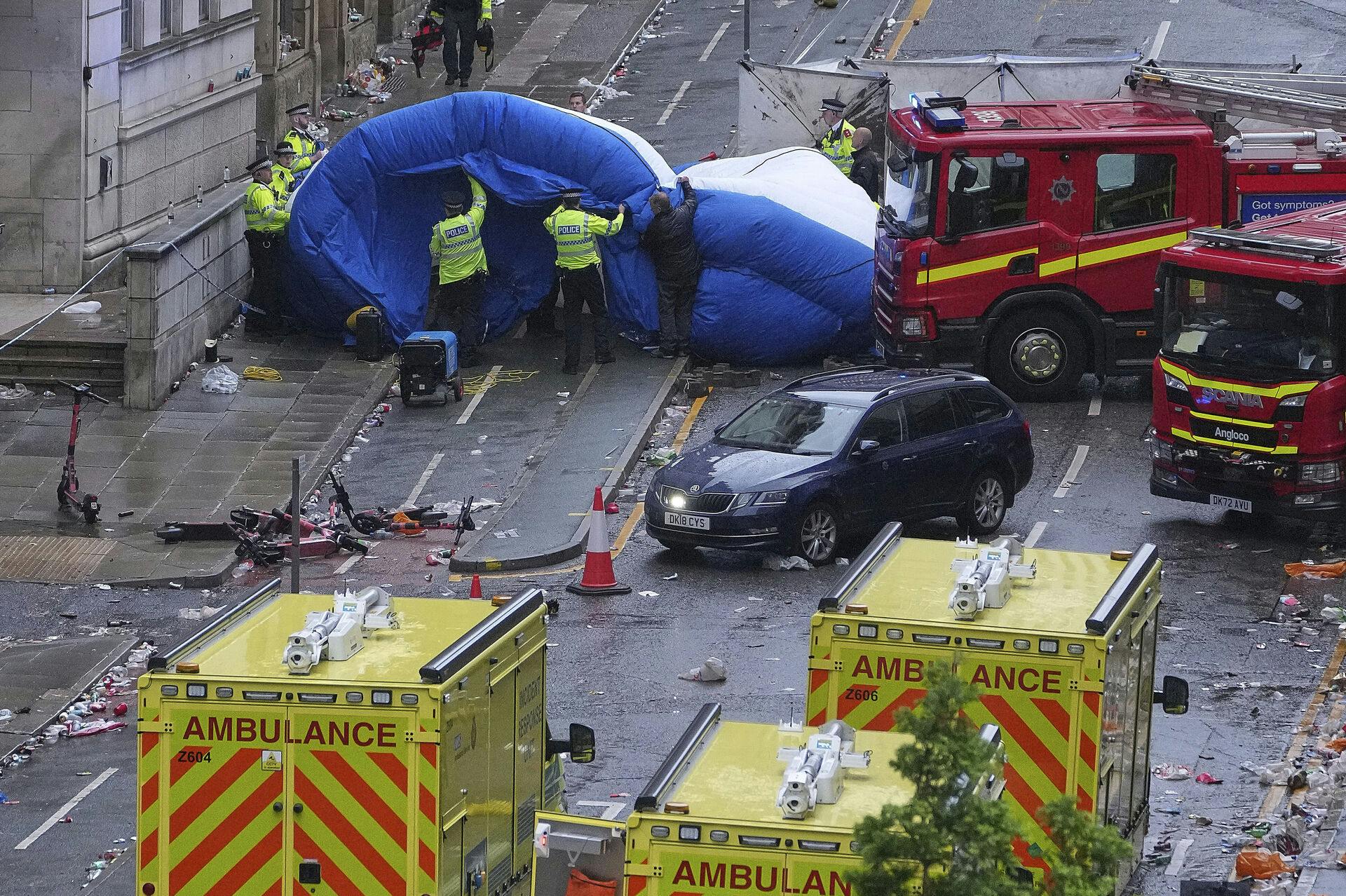 Police and emergency personnel deal with an incident after a car collided with pedestrians near the Liver Building during the Premier League winners parade in Liverpool, England, Monday, May 26, 2025.(AP Photo/Jon Super)