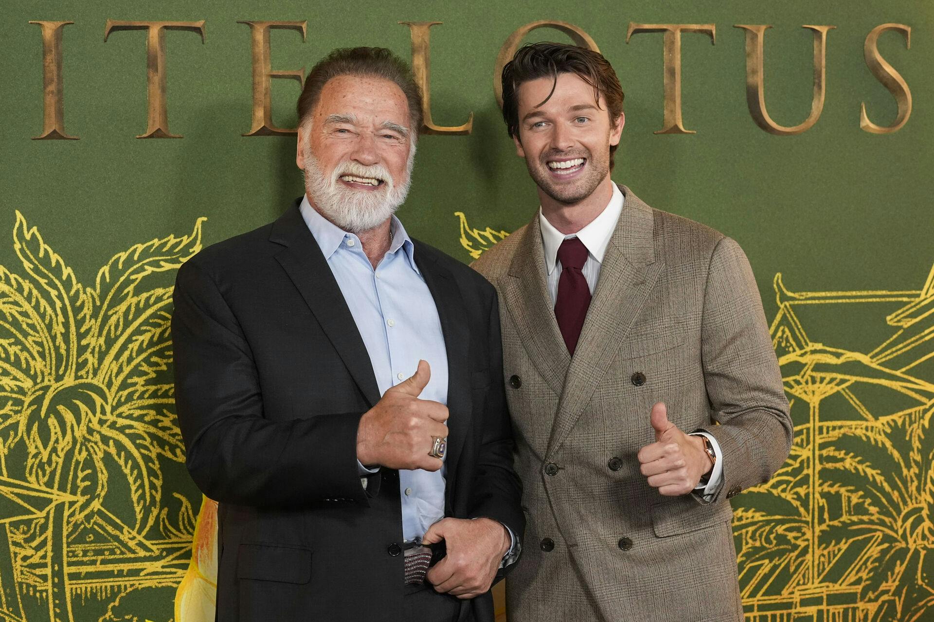 Arnold Schwarzenegger, left, and Patrick Schwarzenegger give the thumbs up at the season three premiere of "The White Lotus" on Monday, Feb. 10, 2025, at Paramount Theater in Los Angeles. (AP Photo/Chris Pizzello)