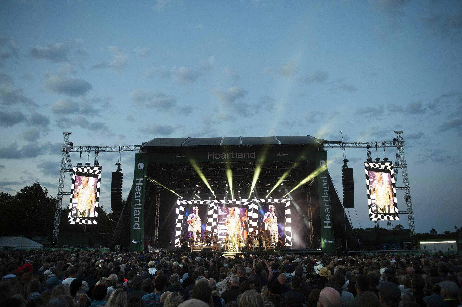 Sådan så det ud, da Robbie Williams optrådte på den ene af scenerne til Heartland Festival i 2023. I aften går Elton John og Bruno Mars blandt andet på.