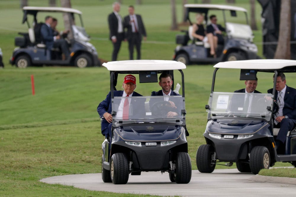 Donald Trump og sønnen Eric Trump kører gennem Trump National Doral Golf Club. Donald Trump ejer flere golfbaner. 