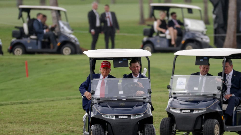 Donald Trump og sønnen Eric Trump kører gennem Trump National Doral Golf Club. Donald Trump ejer flere golfbaner.