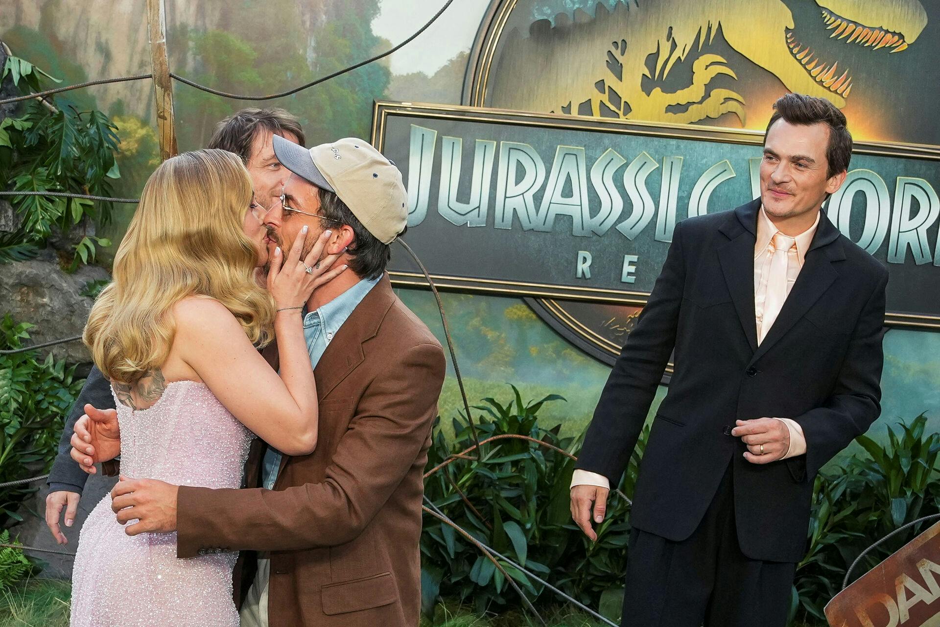 Actors Jonathan Bailey and Scarlett Johansson kiss each other as Rupert Friend looks on during the "Jurassic World Rebirth" global premiere in London, Britain, June 17, 2025. REUTERS/Carlos Jasso