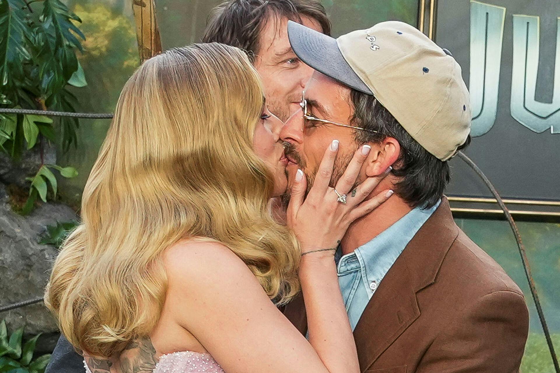 Actors Jonathan Bailey and Scarlett Johansson kiss each other during the "Jurassic World Rebirth" global premiere in London, Britain, June 17, 2025. REUTERS/Carlos Jasso