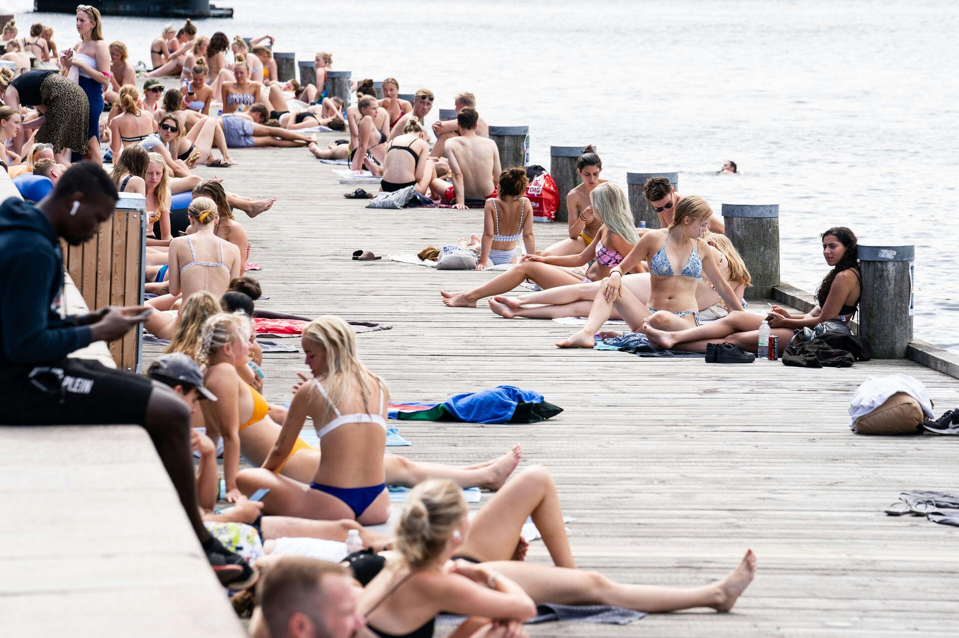 Personer i solen på Islands Brygge i København, torsdag den 6. august 2020. DMI har varslet landsdækkende hedebølge fra torsdag og hen over weekenden.. (Foto: Emil Helms/Ritzau Scanpix)