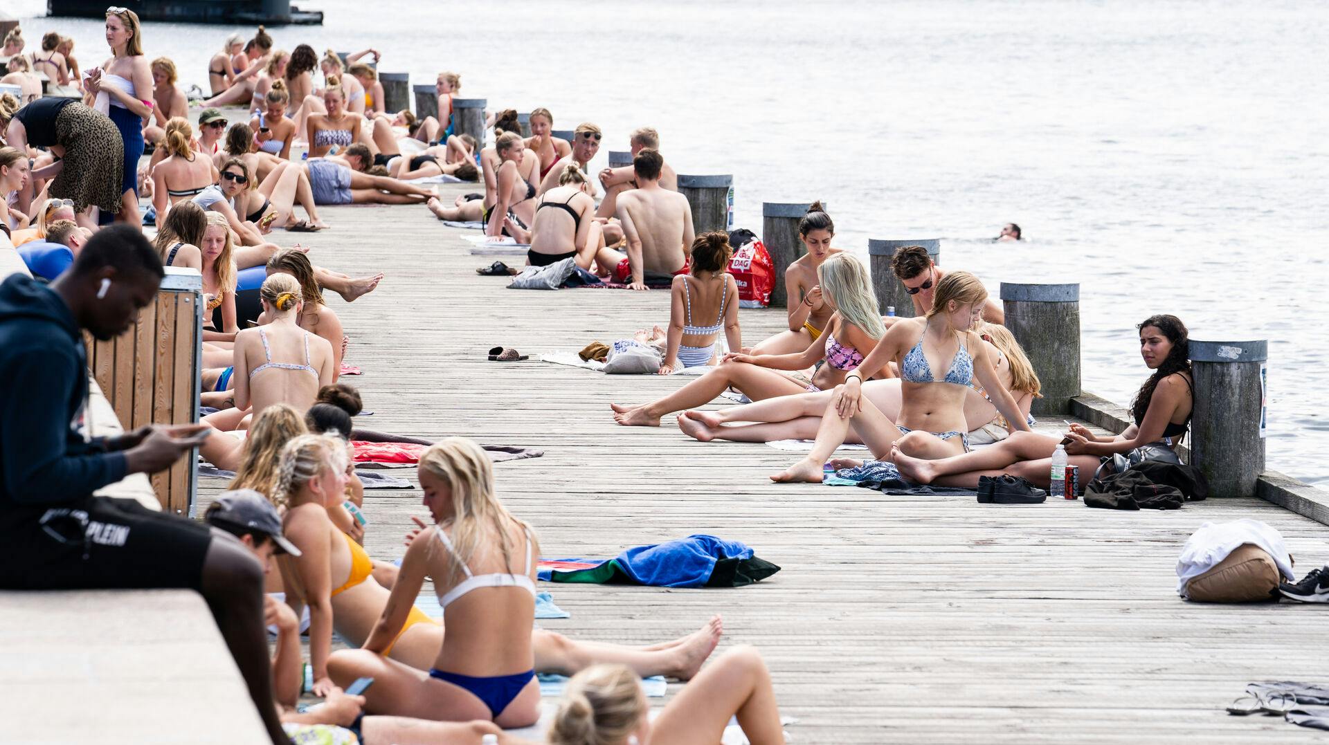 Personer i solen på Islands Brygge i København, torsdag den 6. august 2020. DMI har varslet landsdækkende hedebølge fra torsdag og hen over weekenden.. (Foto: Emil Helms/Ritzau Scanpix)