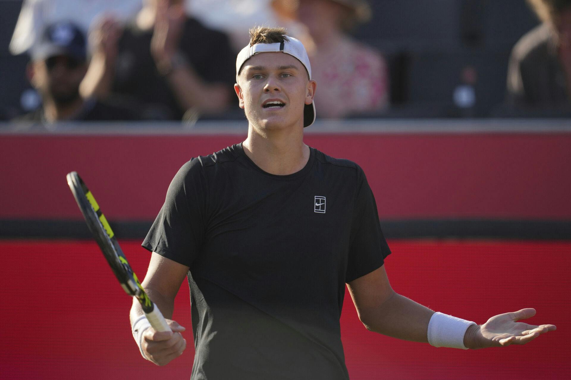 Denmark's Holger Rune reacts during the quarterfinal match of the Queen's Club Championships tennis tournament against Spain's Roberto Bautista Agut in London, Friday, June 20, 2025. (AP Photo/Kin Cheung)