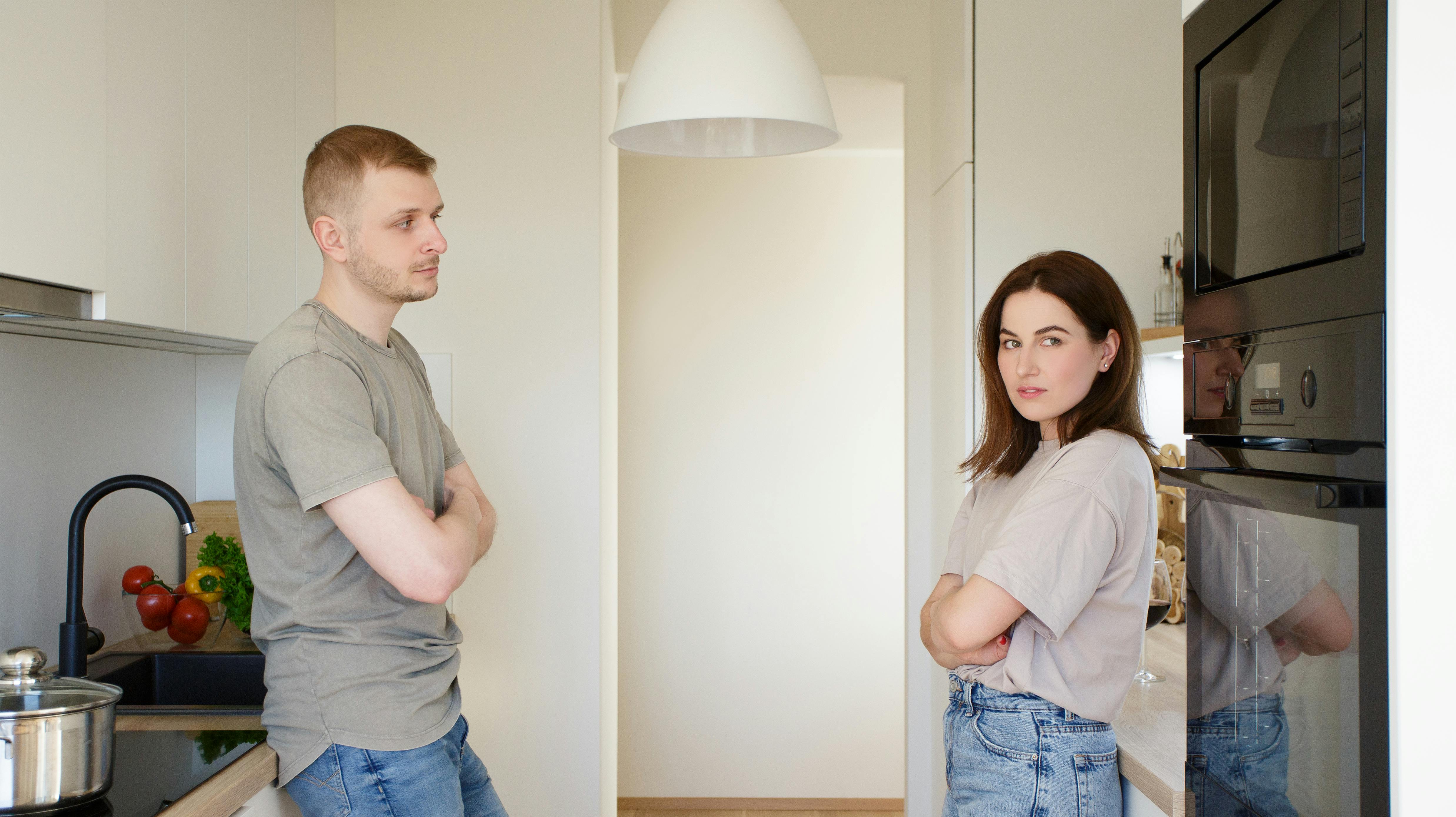 family, relationship and quarrel concept - sad couple standing in the kitchen after quarrel