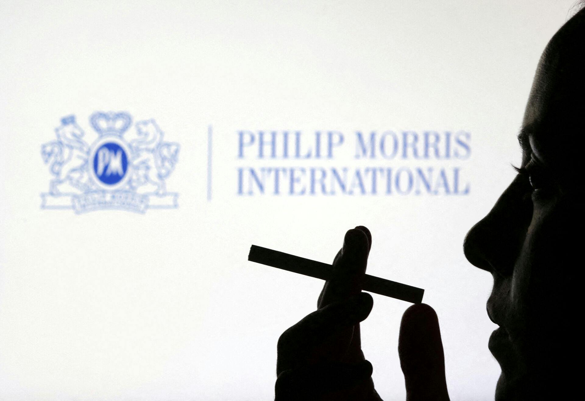 FILE PHOTO: A woman poses with a cigarette in front of Philip Morris International logo in this illustration taken July 26, 2022. REUTERS/Dado Ruvic/Illustration/File Photo