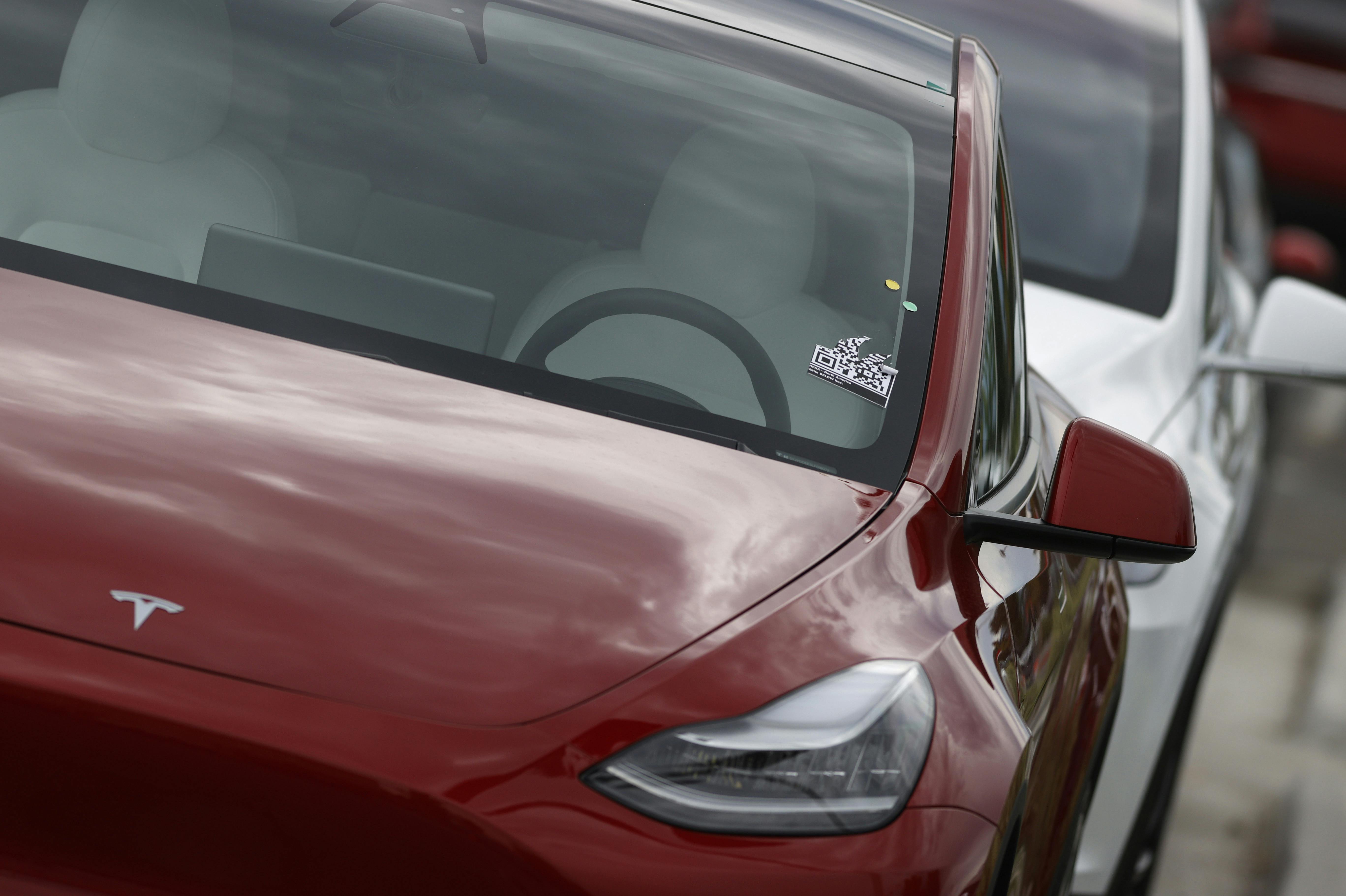 In this Sunday, June 28, 2020, photograph, a long line of unsold 2020 Model Y sports-utility vehicles sits at a Tesla dealership in Littleton, Colo. (AP Photo/David Zalubowski)