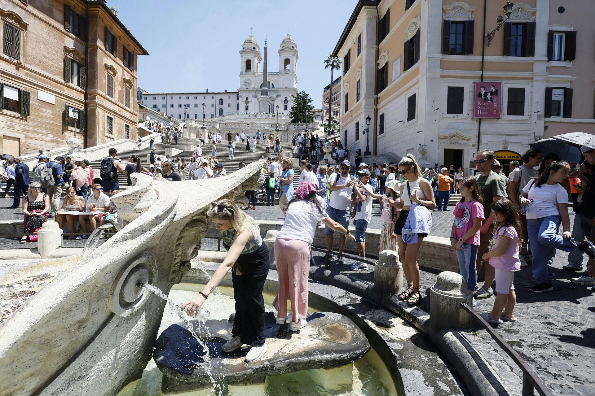 People line up at fountain to refresh themselves on a hot day in Rome's Piazza di Spagna, beneath the Spanish Steps, Tuesday, June 18, 2024. Temperatures are expected to reach 38 degrees C (100 F) over the next days. (Cecilia Fabiano/LaPresse via AP)