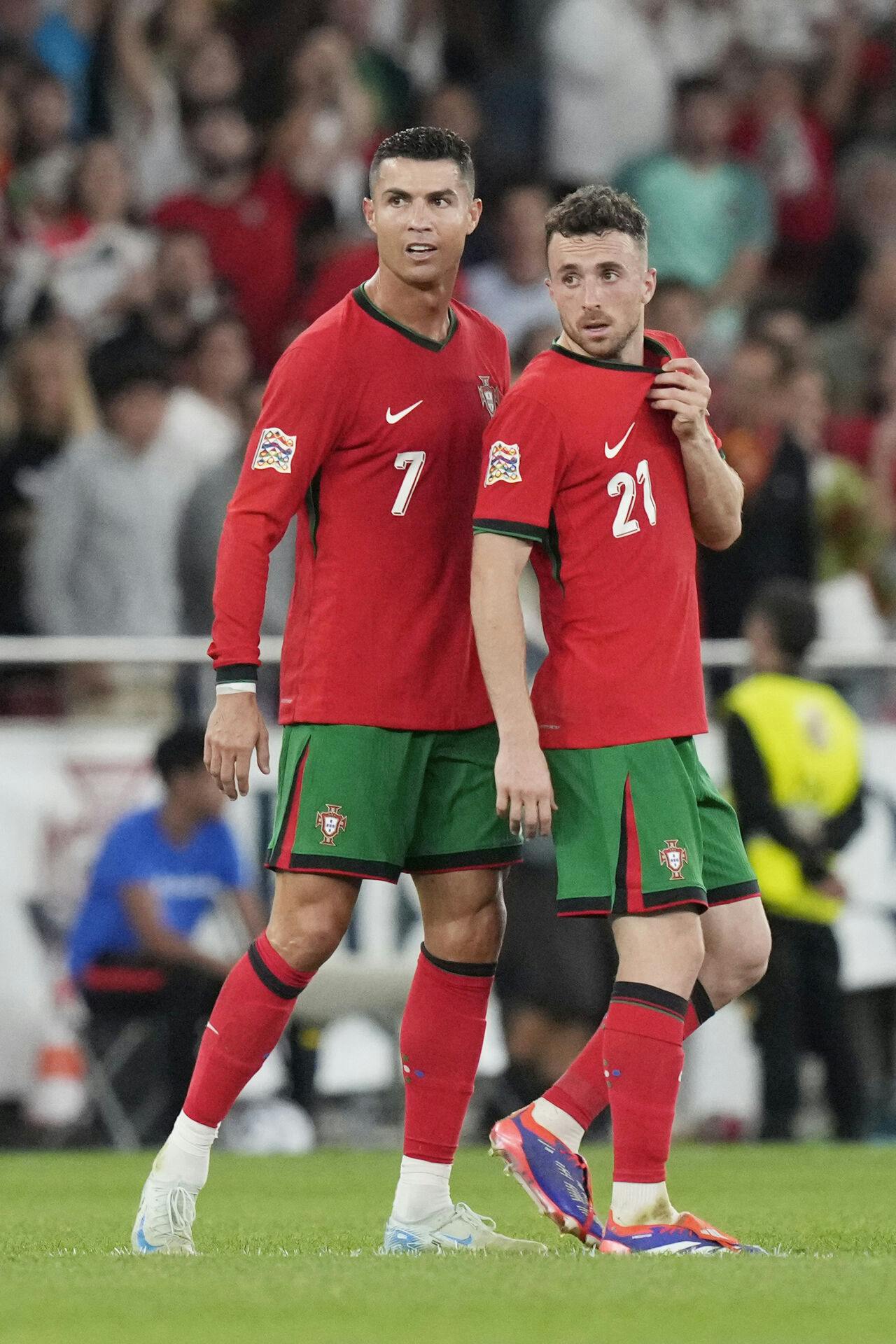 Portugal's Cristiano Ronaldo, left, celebrates after scoring his side's second goal with Diogo Jota during the UEFA Nations League soccer match between Portugal and Scotland at the Luz stadium in Lisbon, Portugal, Sunday, Sept. 8, 2024. (AP Photo/Armando Franca)