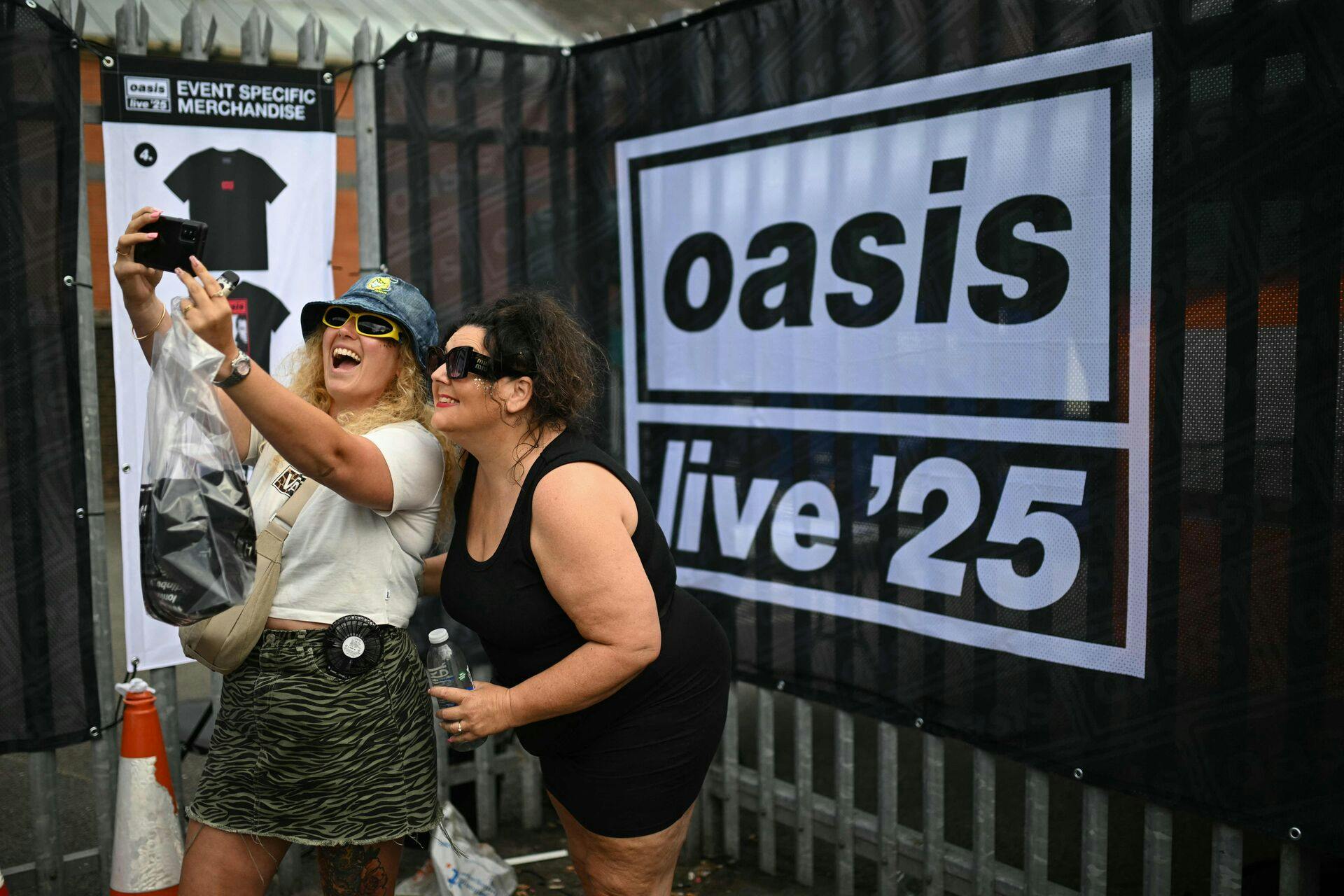 Fans af det britiske rockband Oasis tager en selfie, da de ankommer til Principality Stadium i Cardiff den 4. juli 2025 for at deltage i åbningskoncerten på deres længe ventede genforeningsturné.
