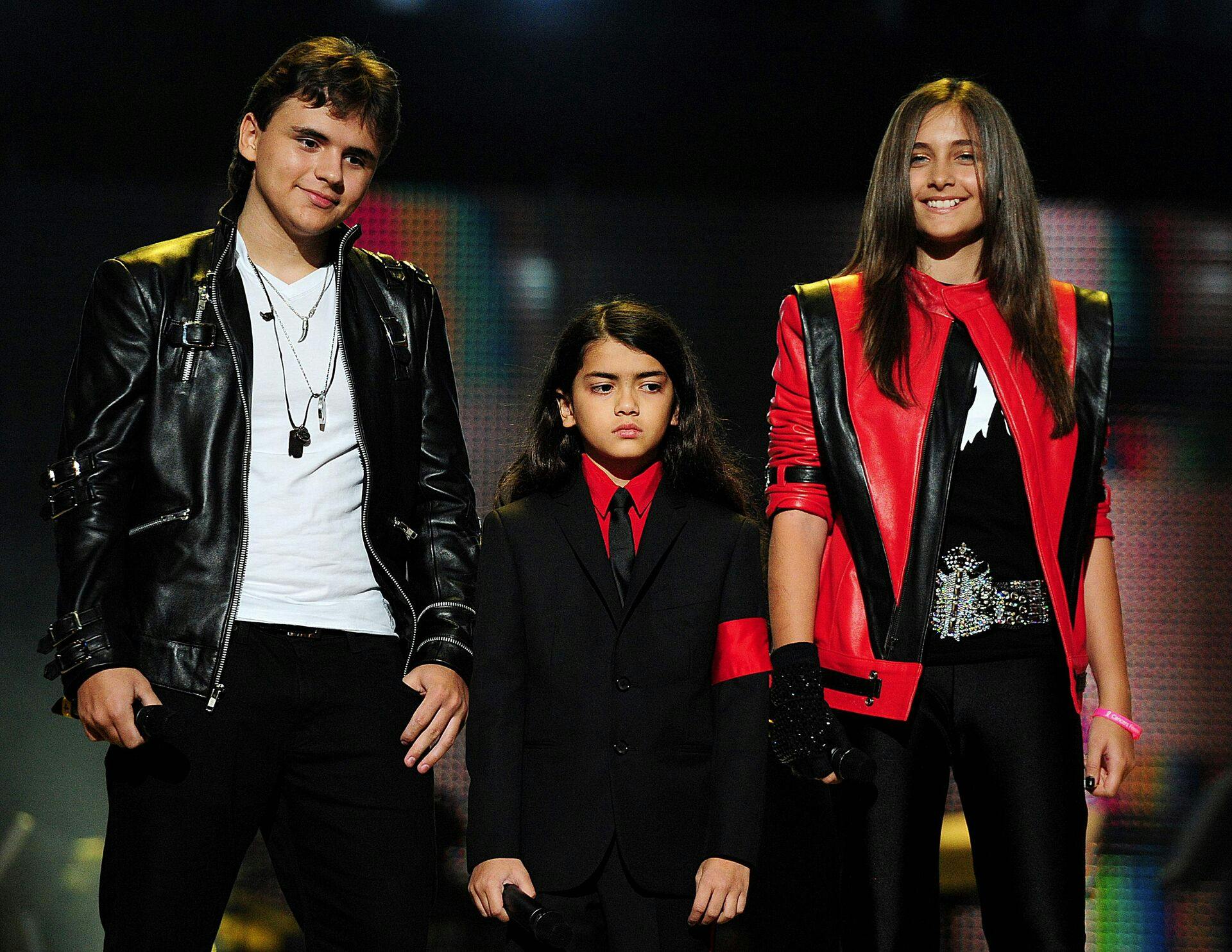 Michael Jacksons børn, Prince Jackson (tv.), Blanket Jackson (i midten) og Paris Jackson (th.) på scenen under 'Michael Forever'-koncerten til minde om deres afdøde far.