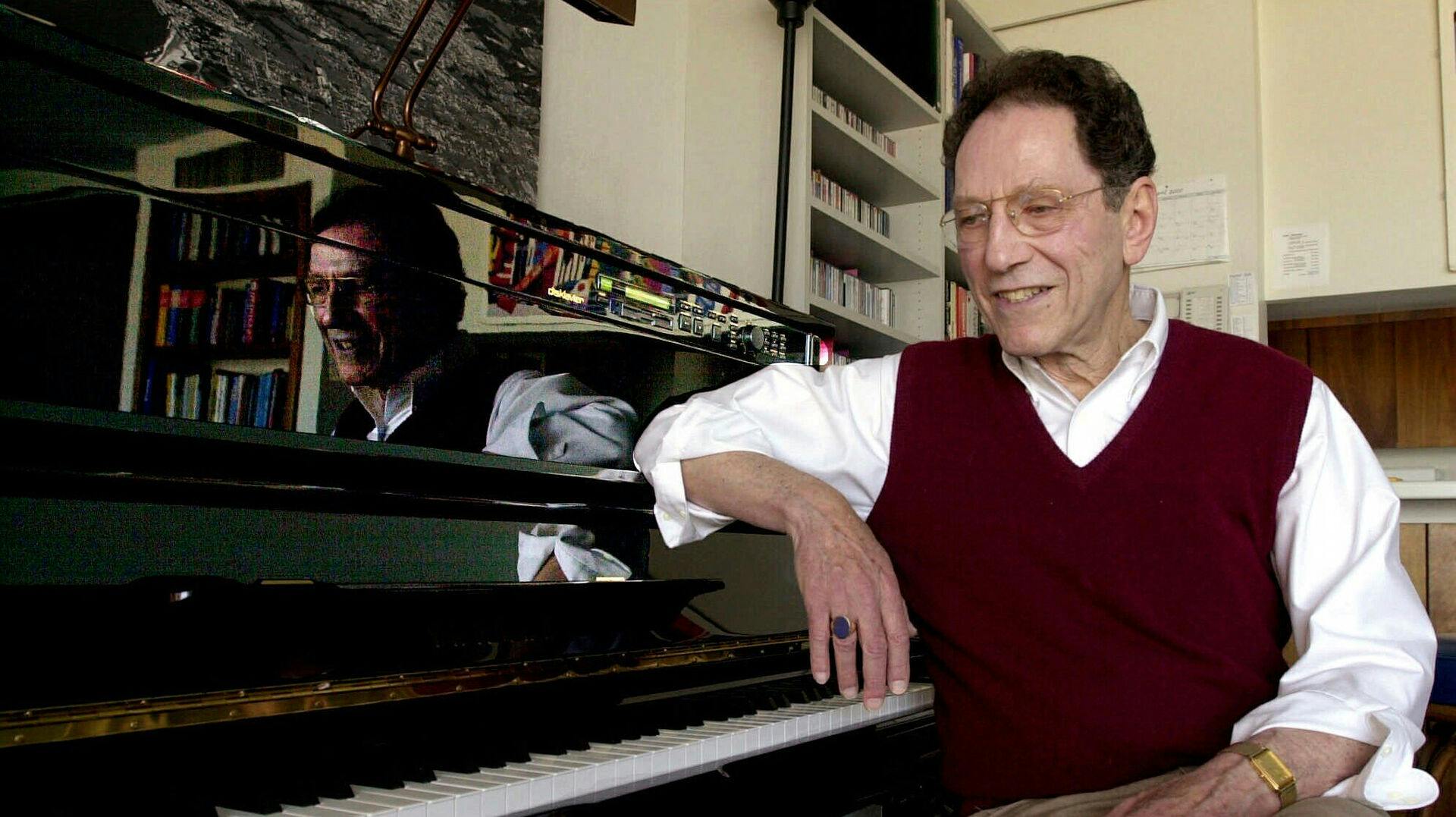 FILE - Musician Tom Lehrer sits beside the piano in his house in Santa Cruz, Calif., on April 21, 2000. (AP Photo/Paul Sakuma, File)
