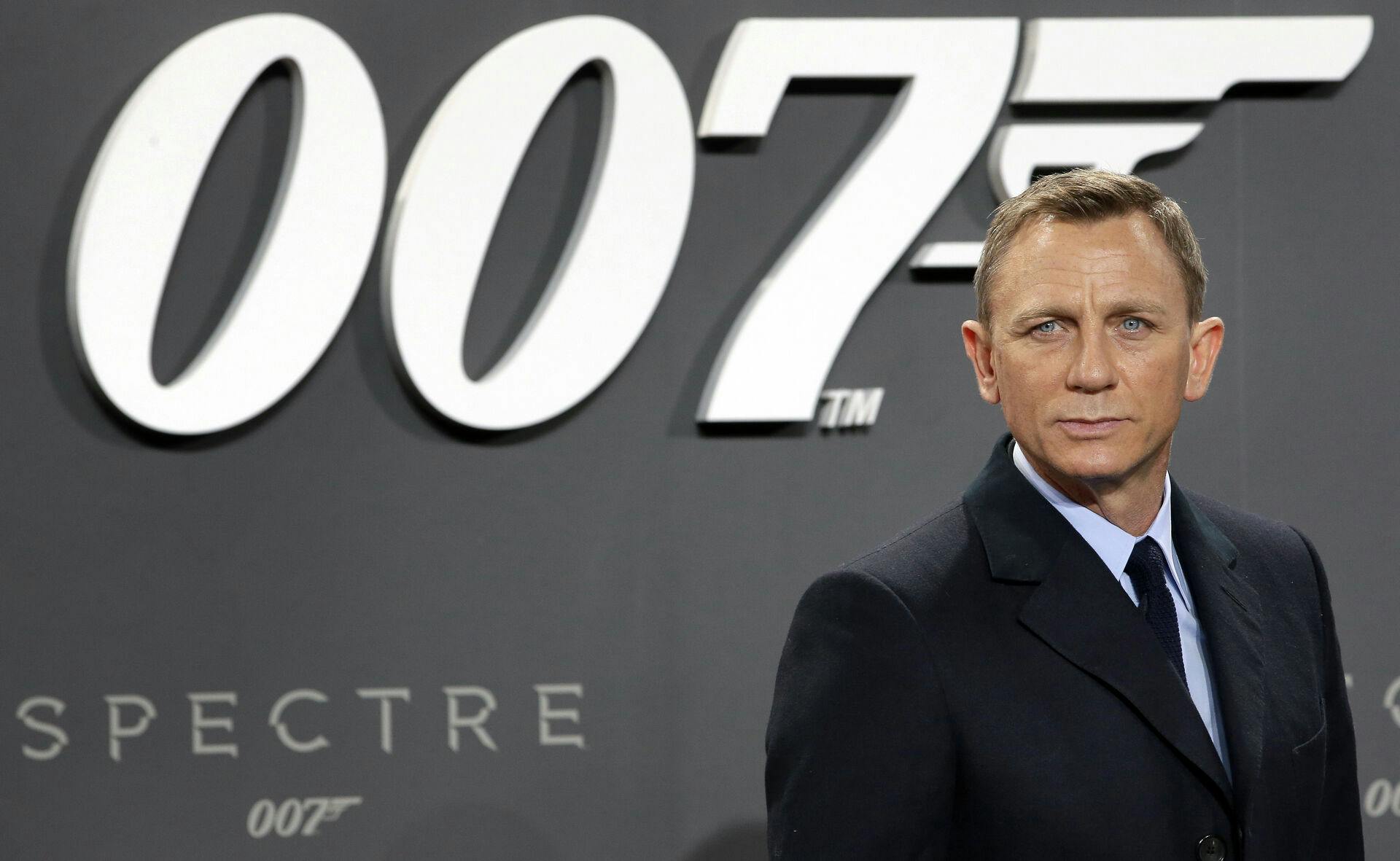Udadtil har Daniel Craig modtaget mest ros for arbejdet som "James Bond". Men nu er et helt andet "James Bond"-ikon gået bort. Nemlig manden bag 007-logoet, som ses her bag Daniel Craig.
