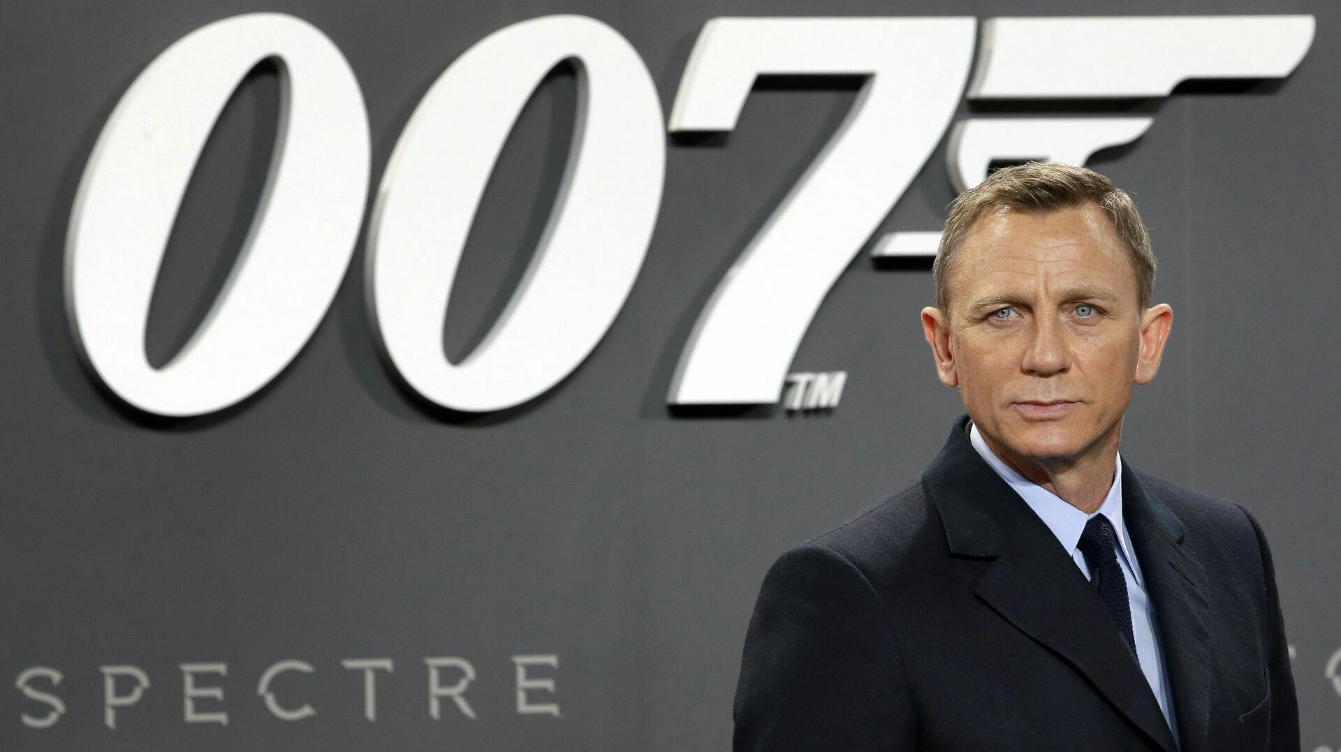 Udadtil har Daniel Craig modtaget mest ros for arbejdet som "James Bond". Men nu er et helt andet "James Bond"-ikon gået bort. Nemlig manden bag 007-logoet, som ses her bag Daniel Craig.