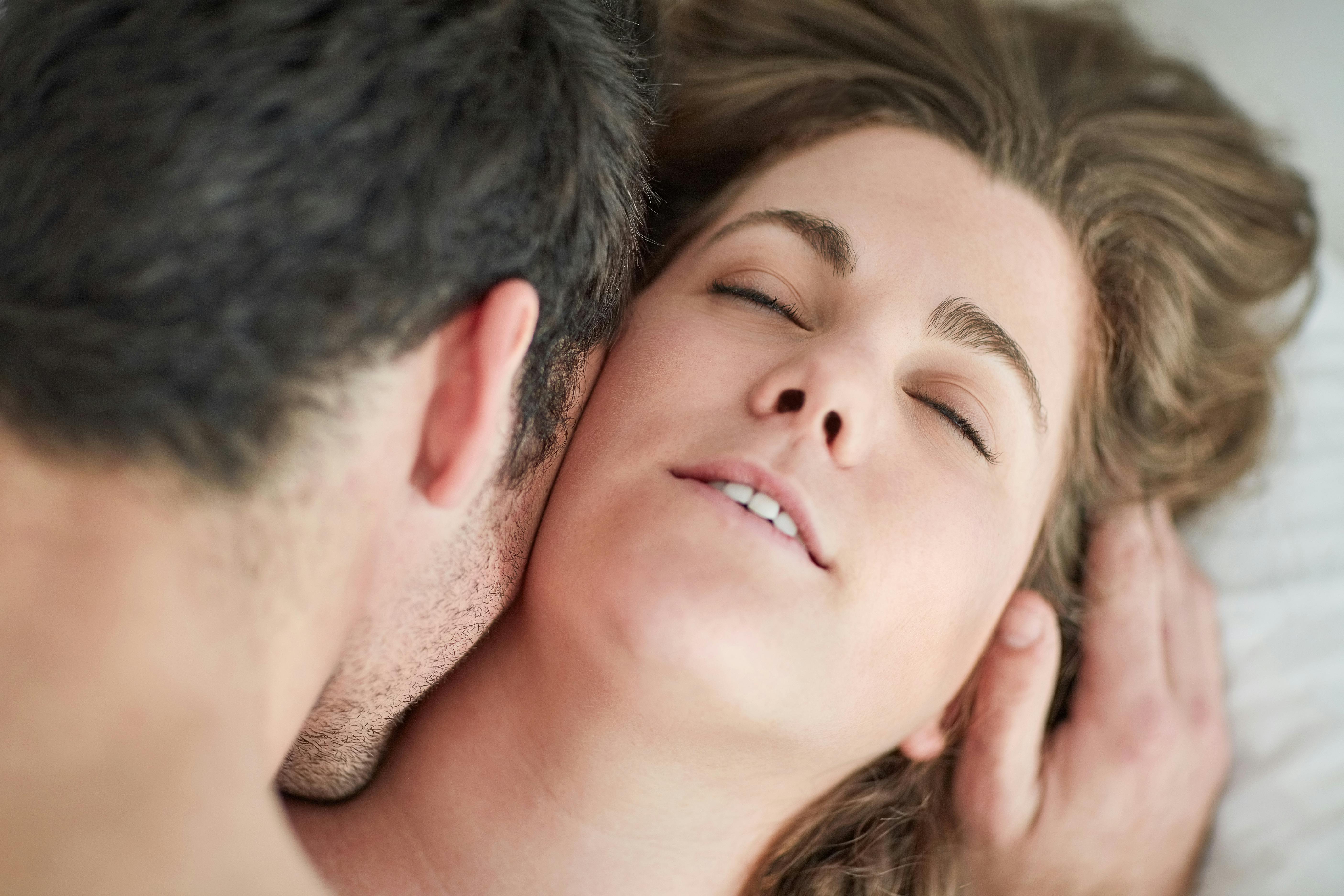 Kiss, love and couple in bed with romance, intimacy and desire, connection and bonding in their home from above. Foreplay, top view and people in a bedroom with passion for honeymoon or anniversary.