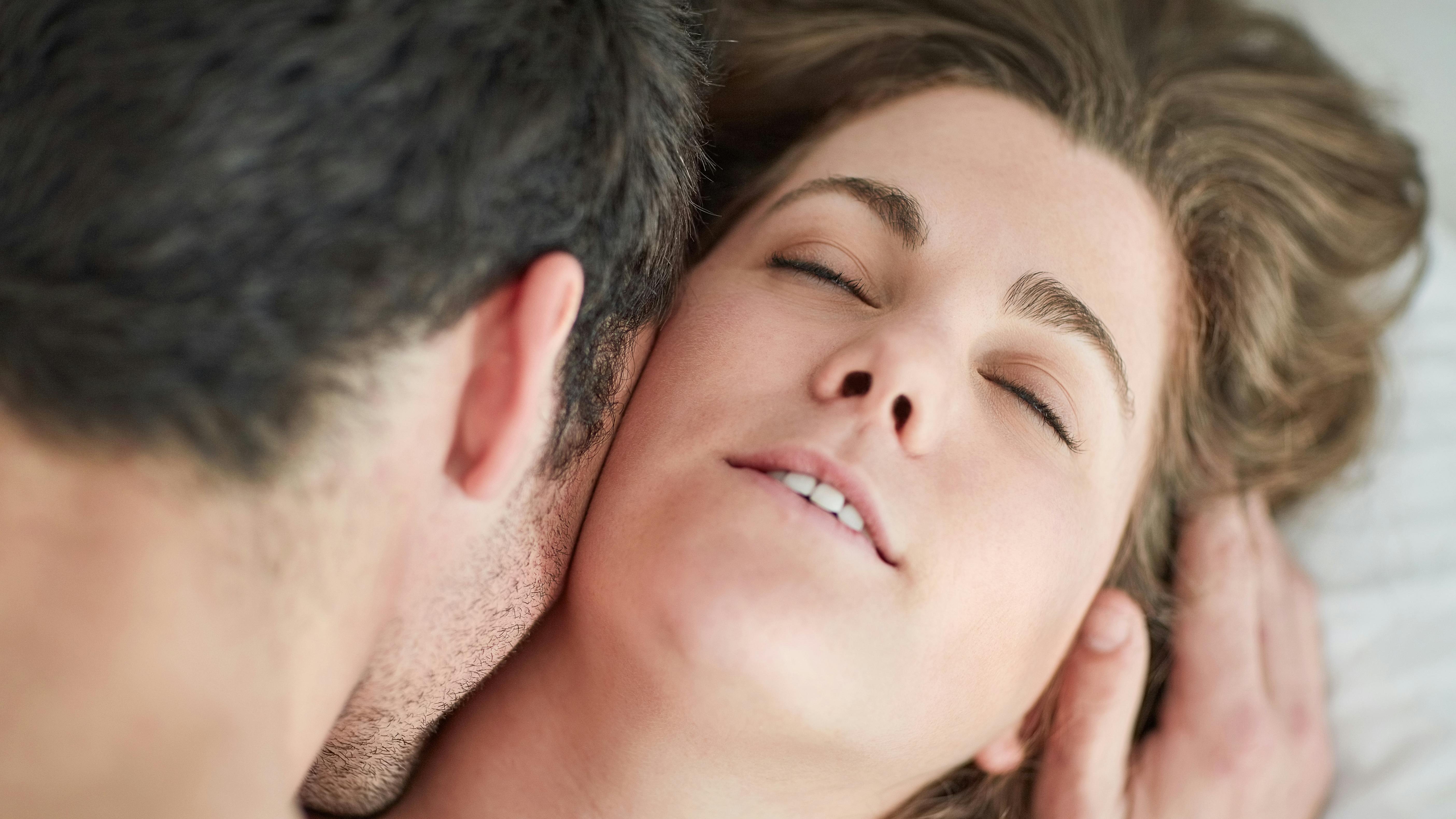 Kiss, love and couple in bed with romance, intimacy and desire, connection and bonding in their home from above. Foreplay, top view and people in a bedroom with passion for honeymoon or anniversary.