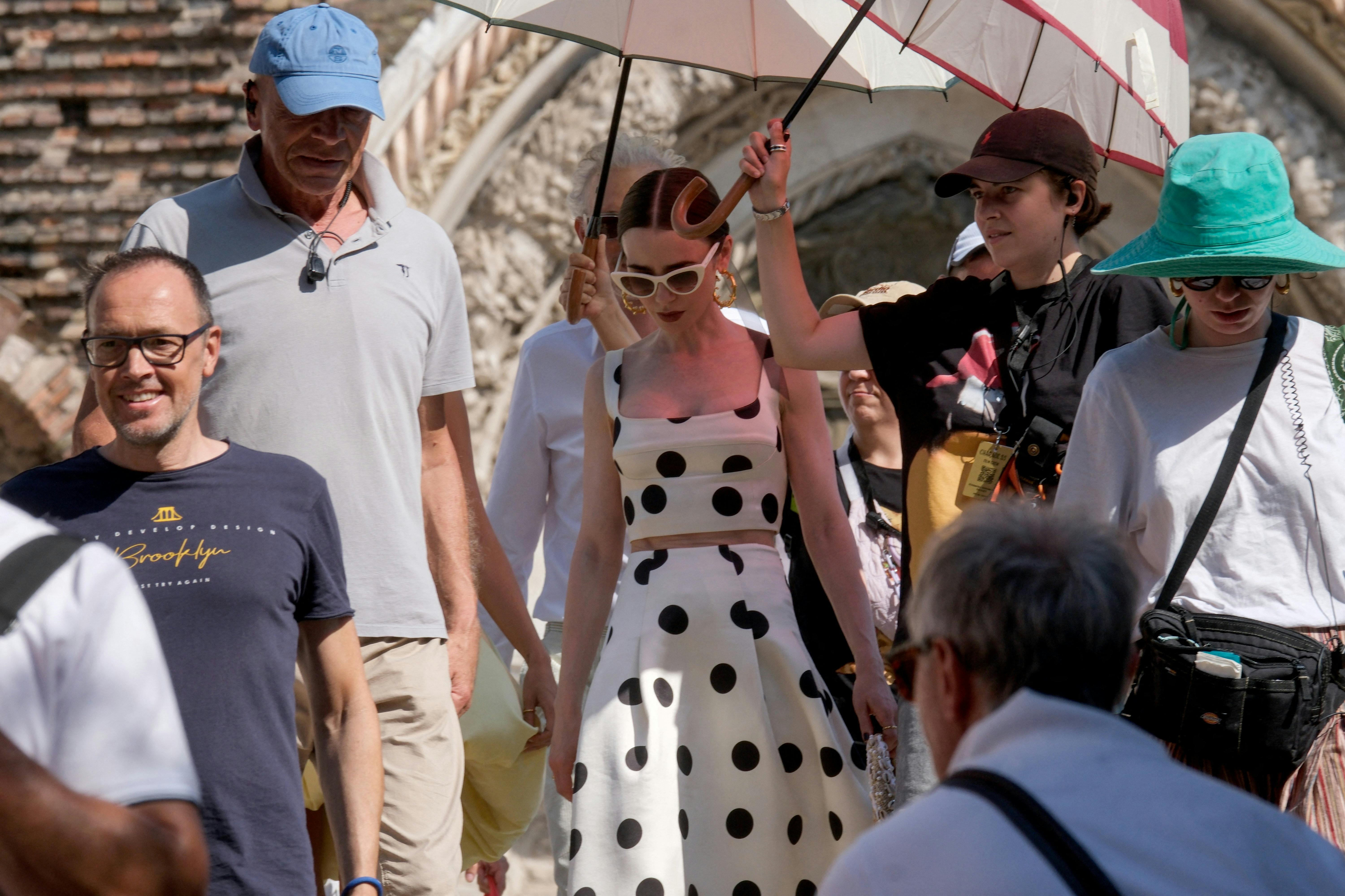 Actress Lily Collins walks in the street during production of Season 5 of Netflix's "Emily in Paris", in Venice, Italy, August 18, 2025. REUTERS/Manuel Silvestri