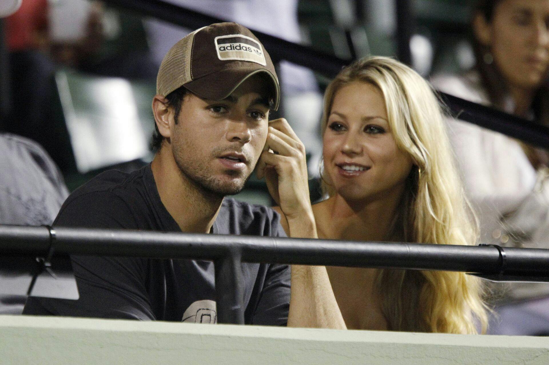Spain's singer Enrique Iglesias and former Russian tennis player Anna Kournikova attend the semi-final match between Venus Williams and Serena Williams of the U.S. at the Sony Ericsson Open tennis tournament in Key Biscayne, Florida April 2, 2009. REUTERS/Carlos Barria (UNITED STATES SPORT TENNIS)