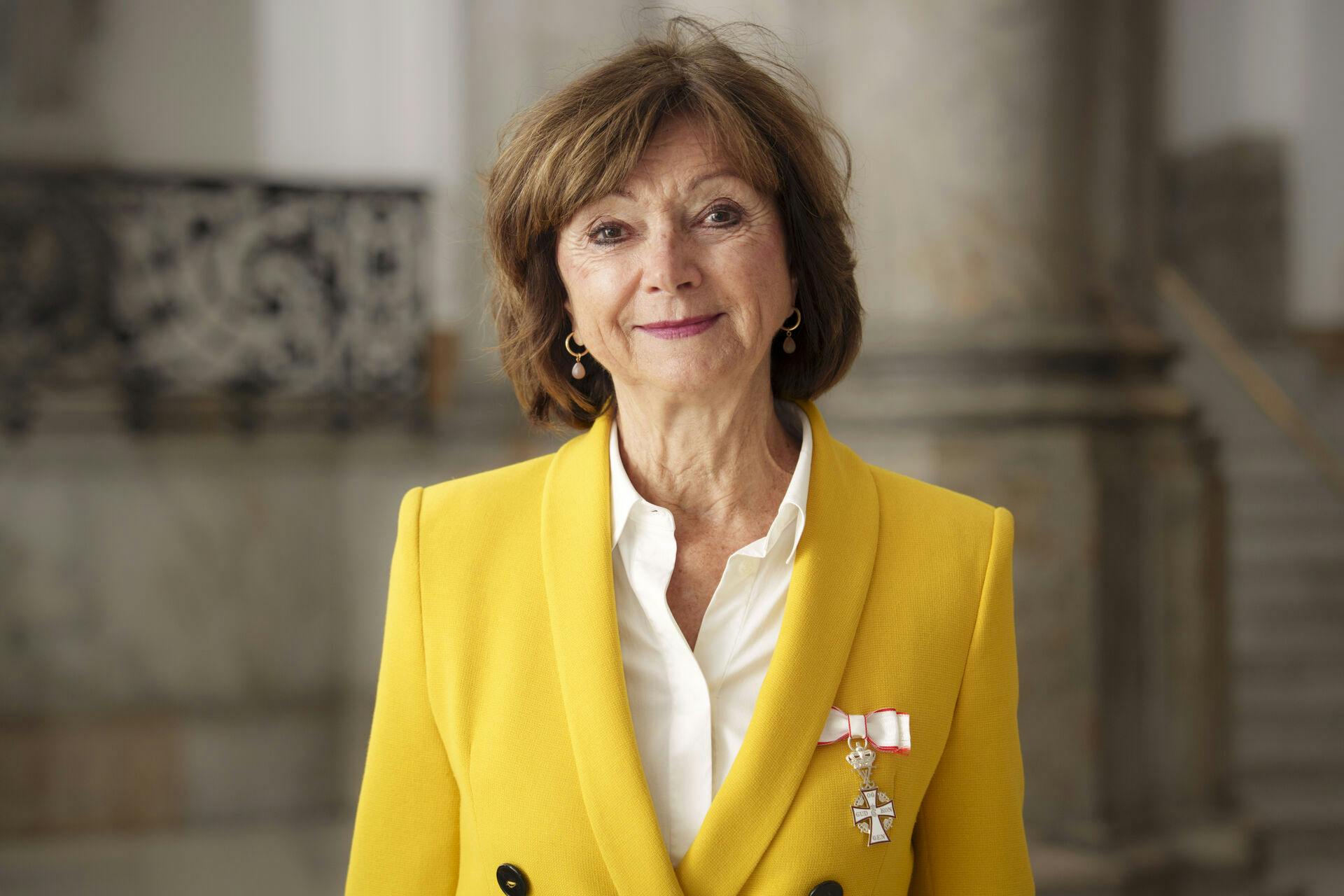 Smilende og tydeligt rørt viser Sonja Oppenhagen Ridderkorset frem efter audiensen hos kong Frederik.