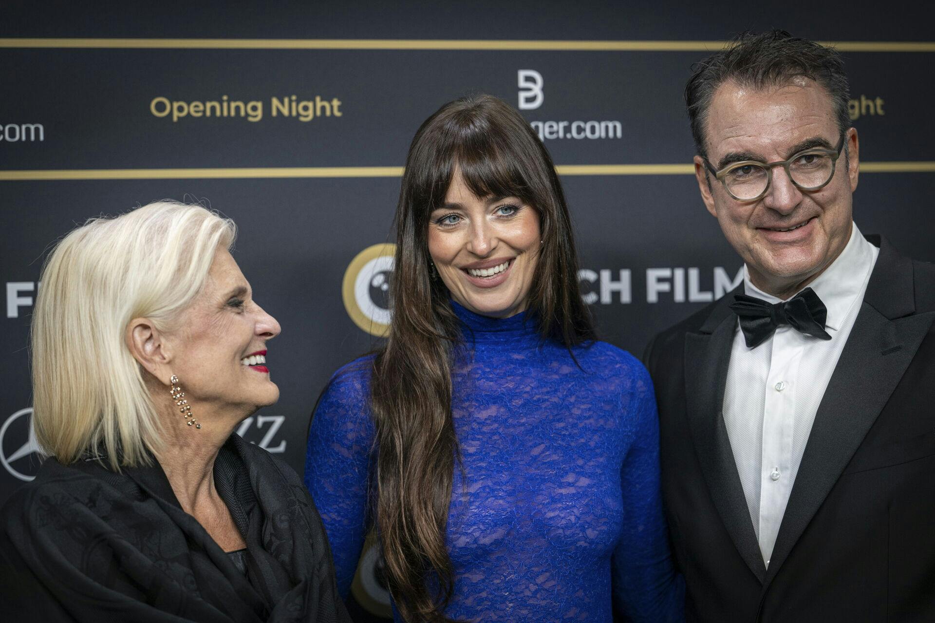 epa12405806 (L-R) ZFF President Doris Fiala, US actor and film producer Dakota Johnson and ZFF Artistic Director Christian Jungen pose on the green carpet at the opening day of the Zurich Film Festival (ZFF), in Zurich, Switzerland, 25 September 2025. The 21st edition of the ZFF runs from 25 September to 05 October 2025. EPA/ANDREAS BECKER