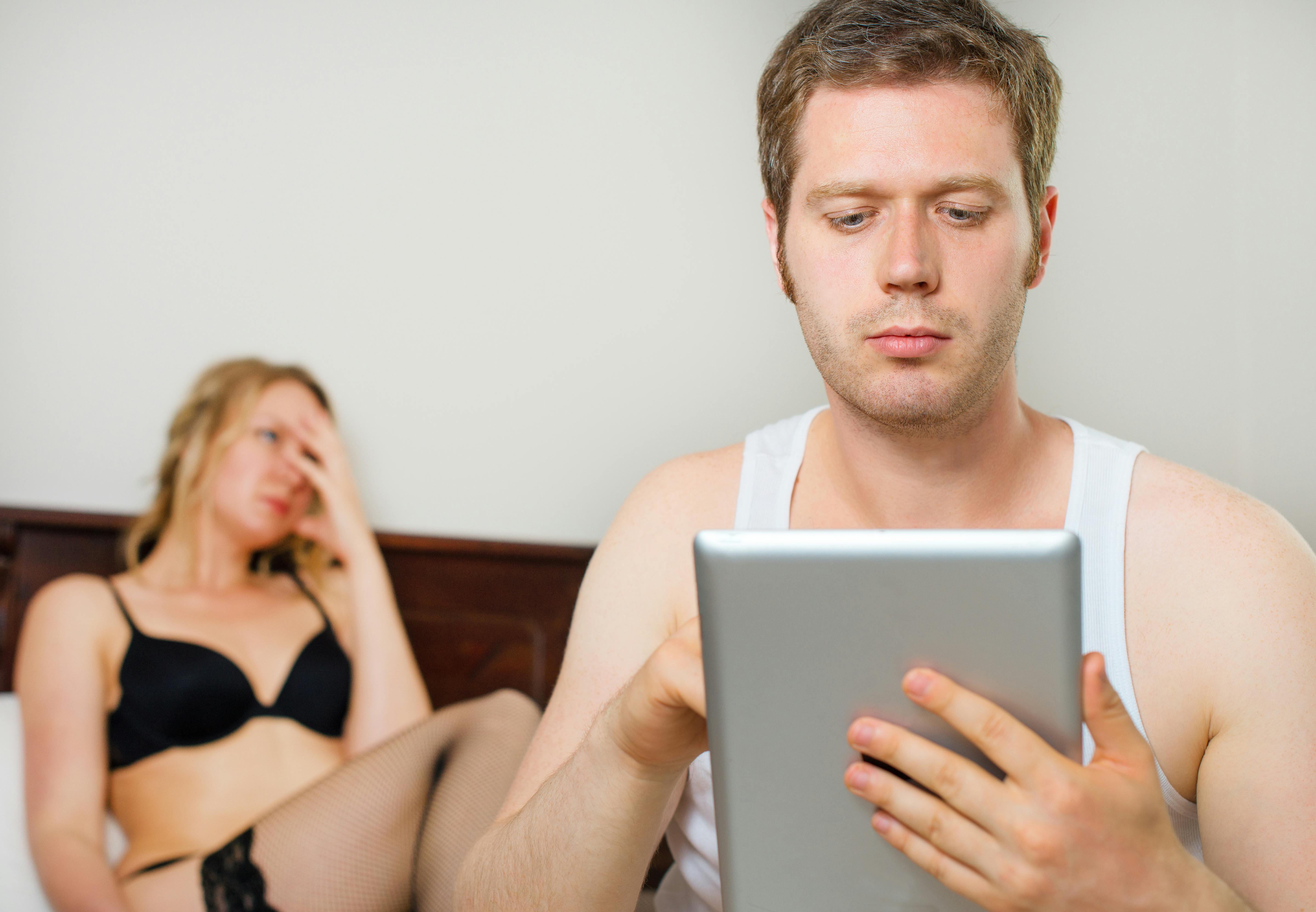 Man using tablet pc. Upset woman on background.