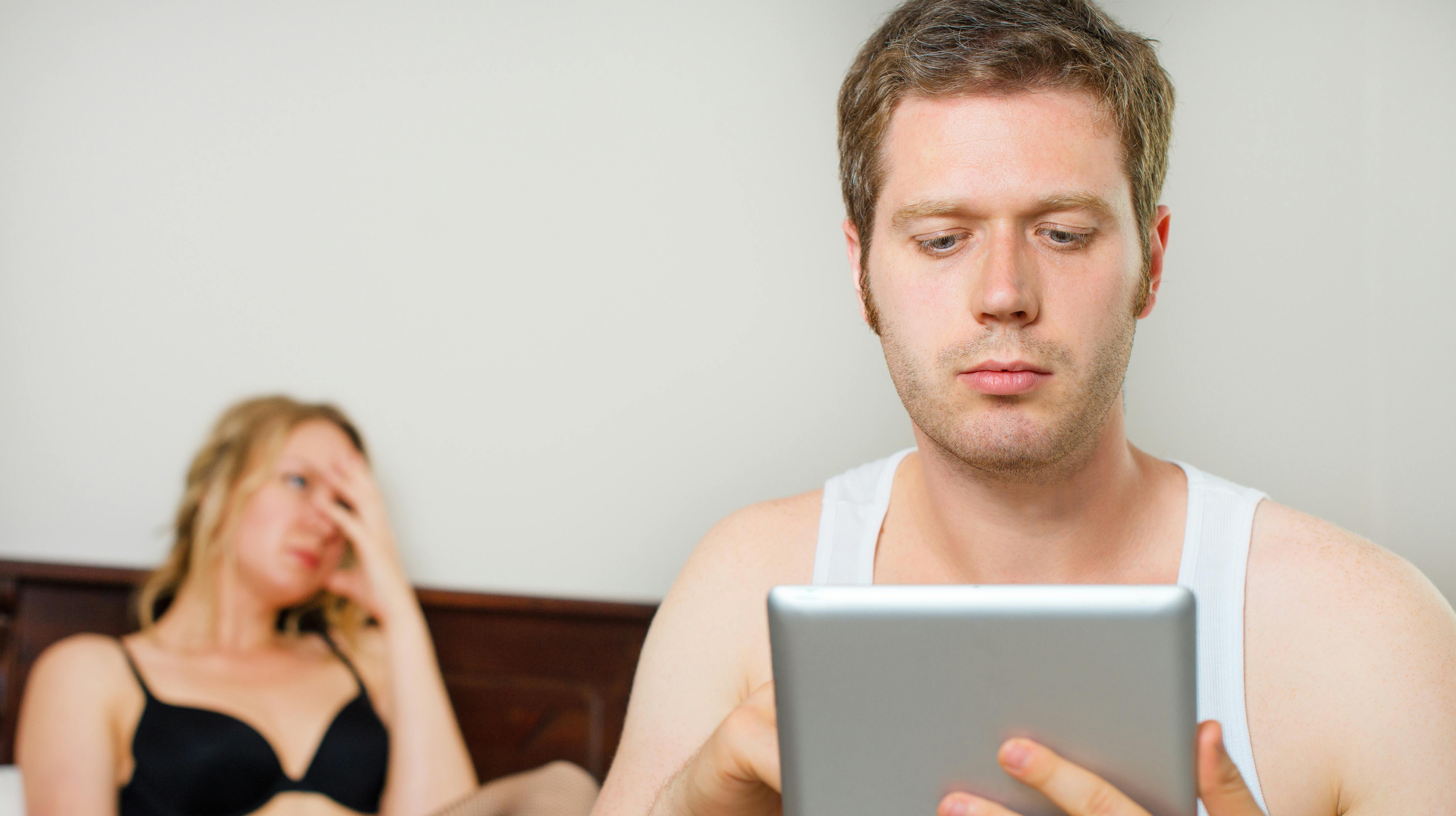 Man using tablet pc. Upset woman on background.