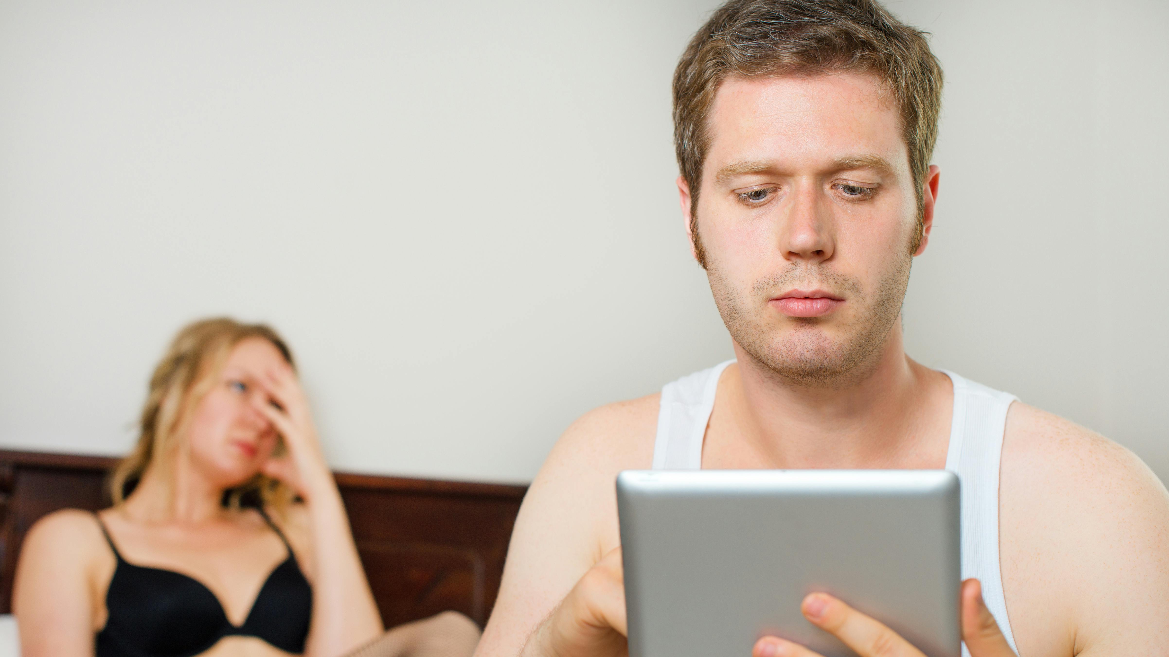 Man using tablet pc. Upset woman on background.