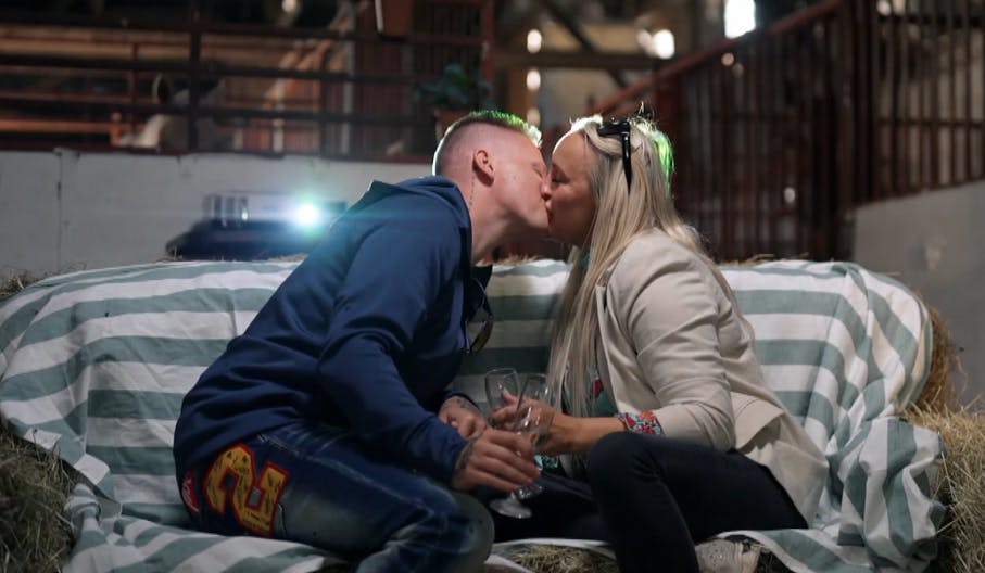 Chris og Kimi kysser på den hjemmelavede hø-divan på filmdate i stalden.